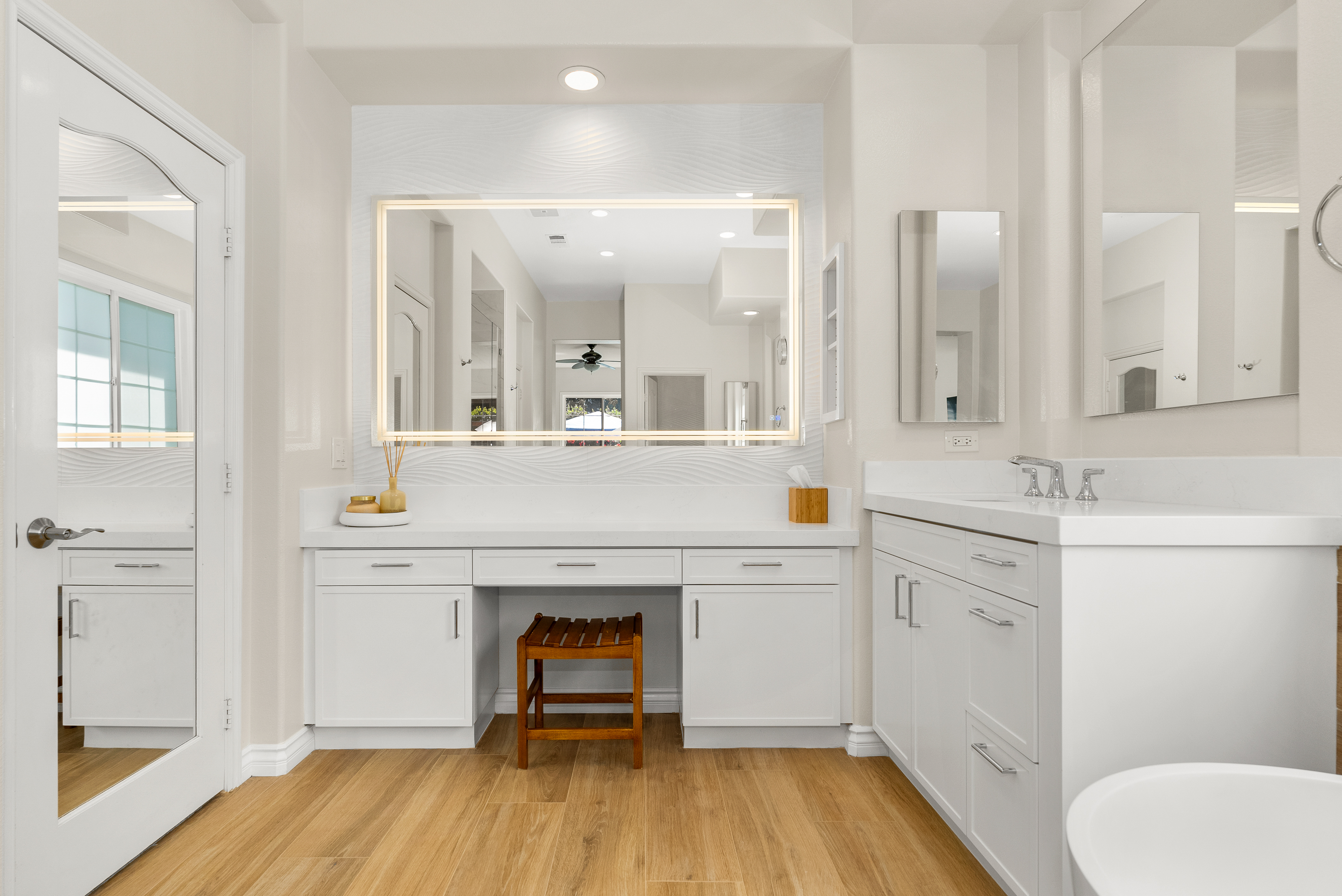 Illuminated mirror above dual sinks in modern vanity