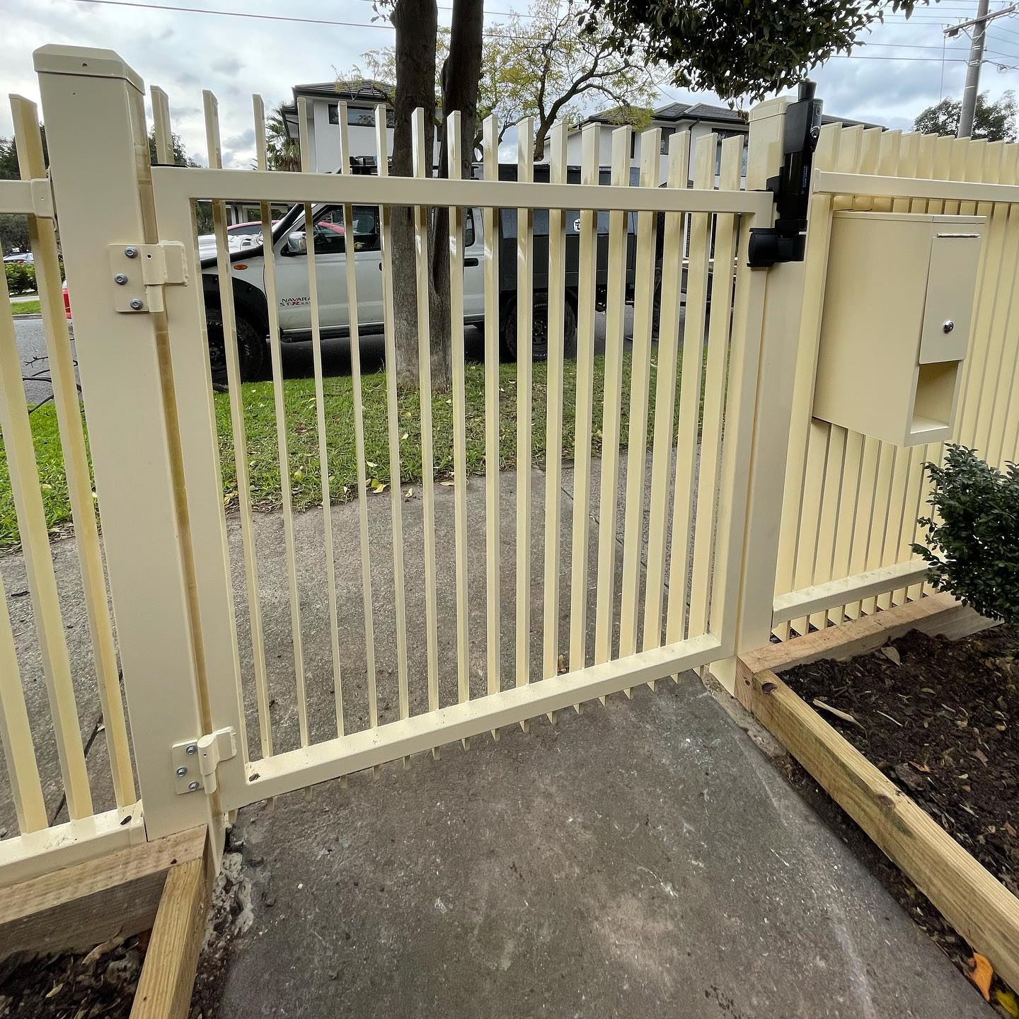 Beige metal fence with gate hinges