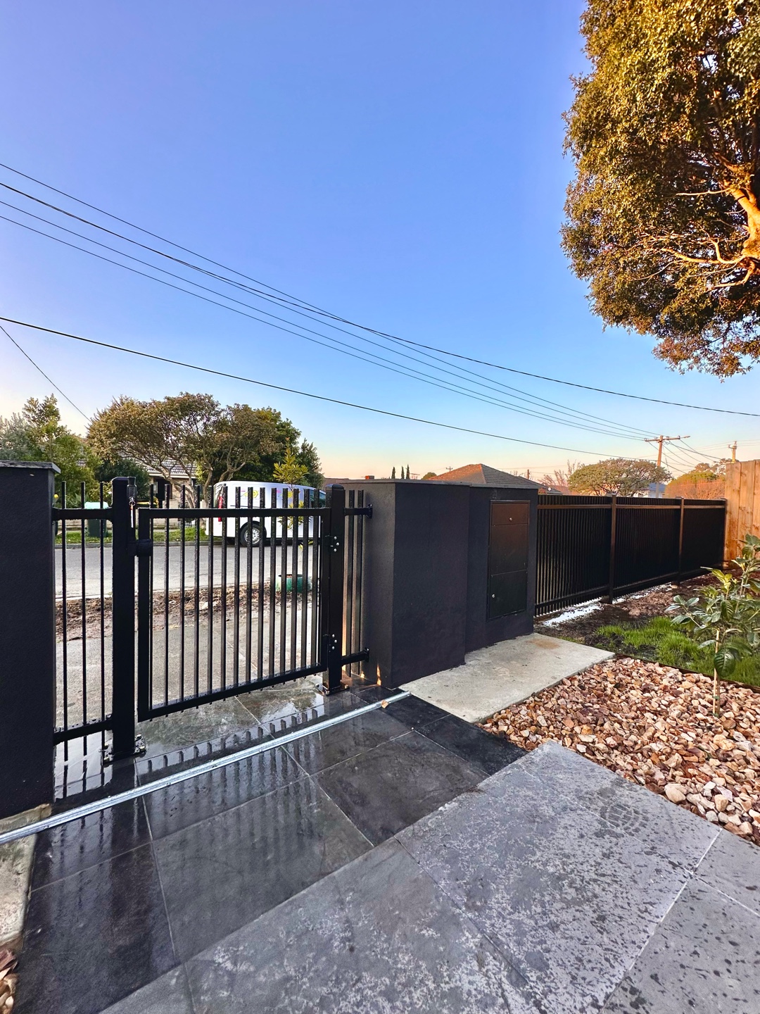 Pedestrian gate integrated into black metal blade fence
