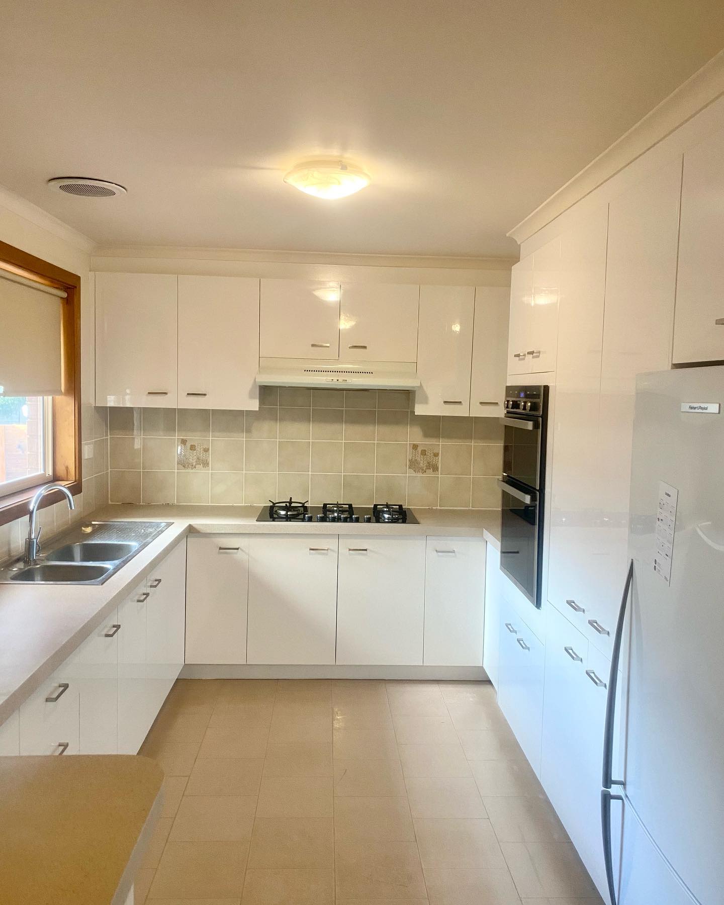 Modernized kitchen with white cabinetry after renovation