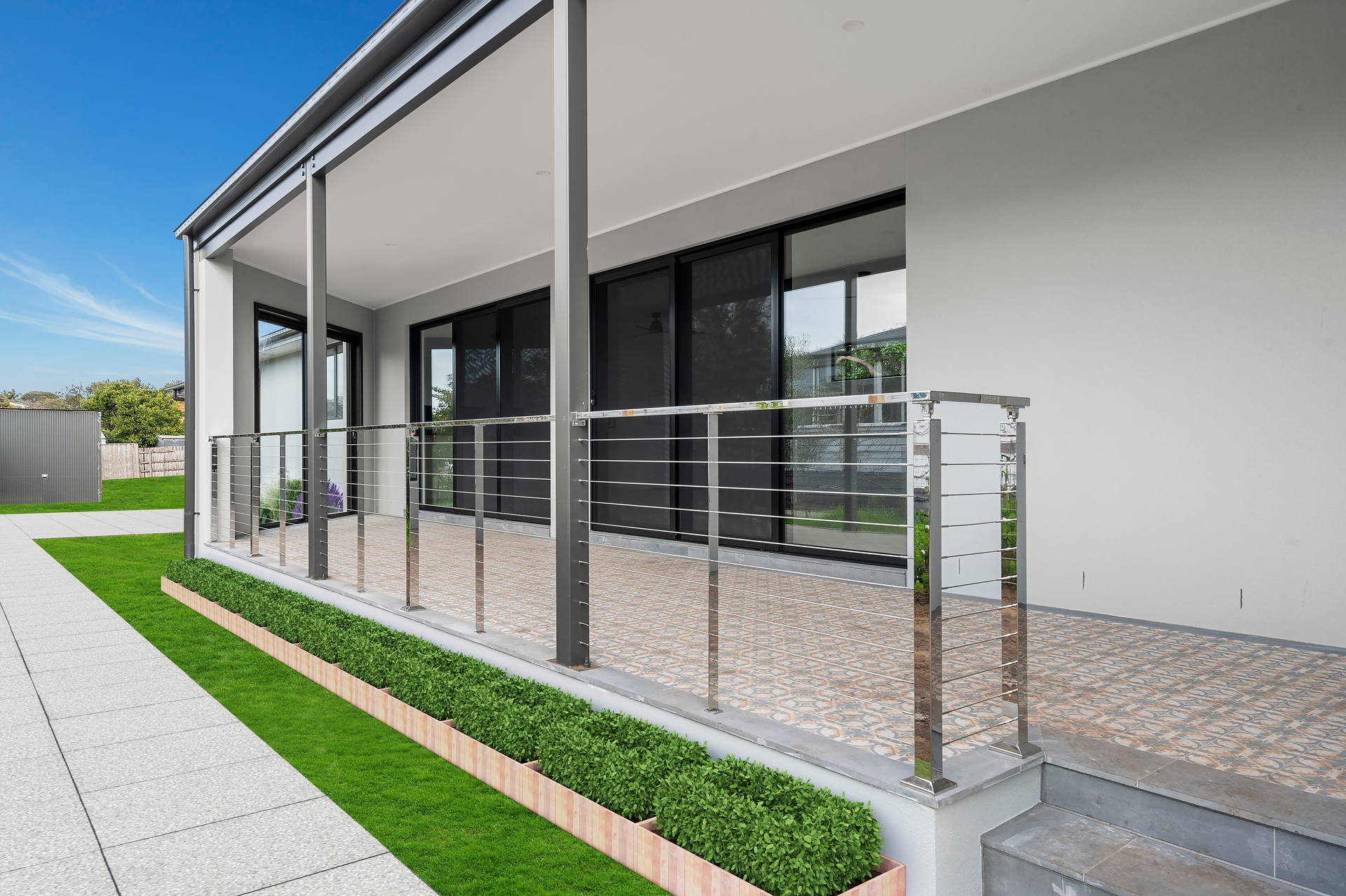 Modern house exterior with covered porch and large glass sliding doors