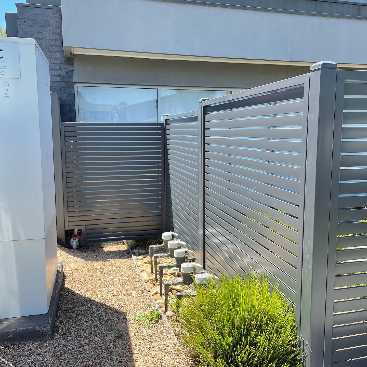 Metallic grey slat fencing around building perimeter