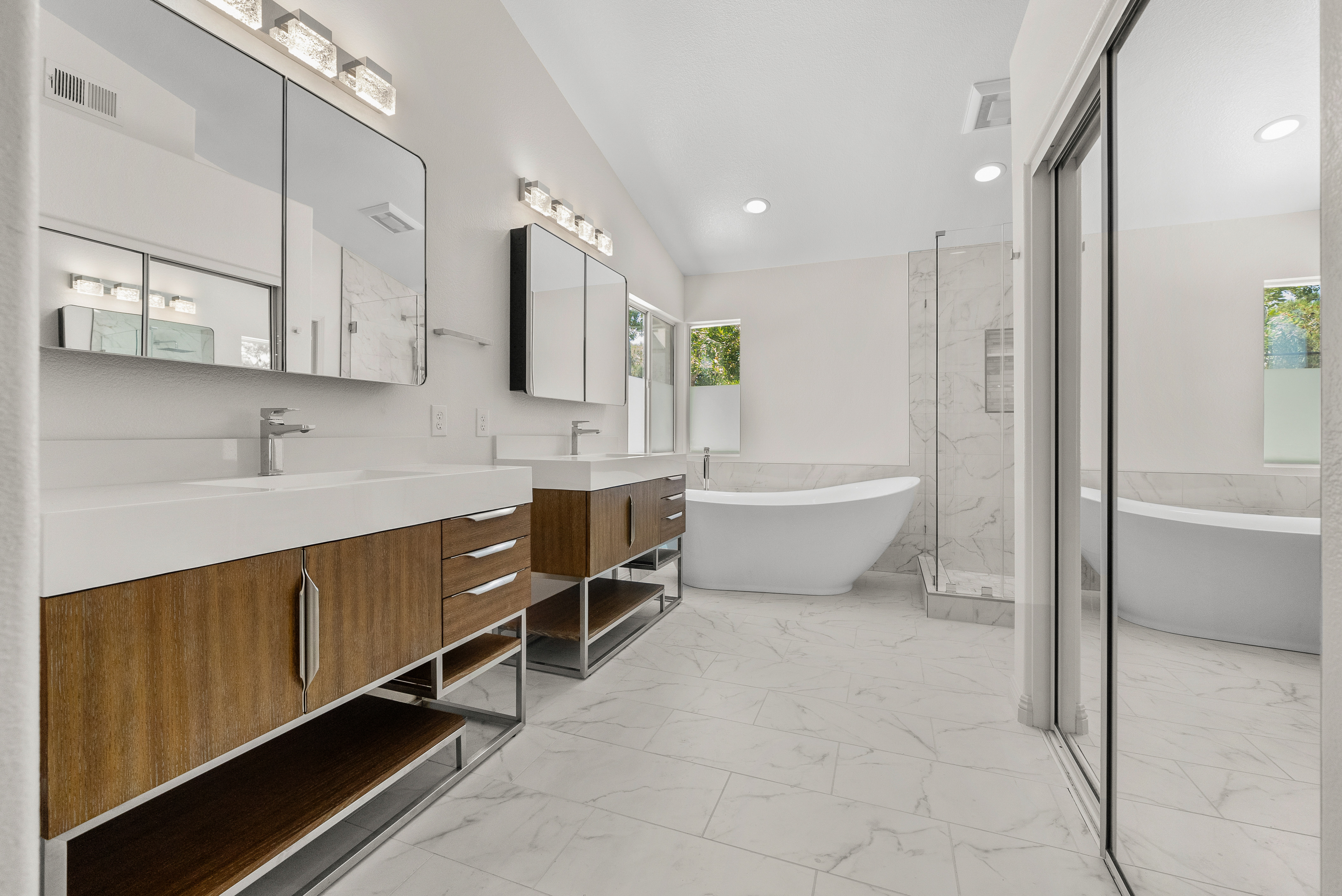 Modern wooden vanities with white countertops in San Marcos bathroom remodel