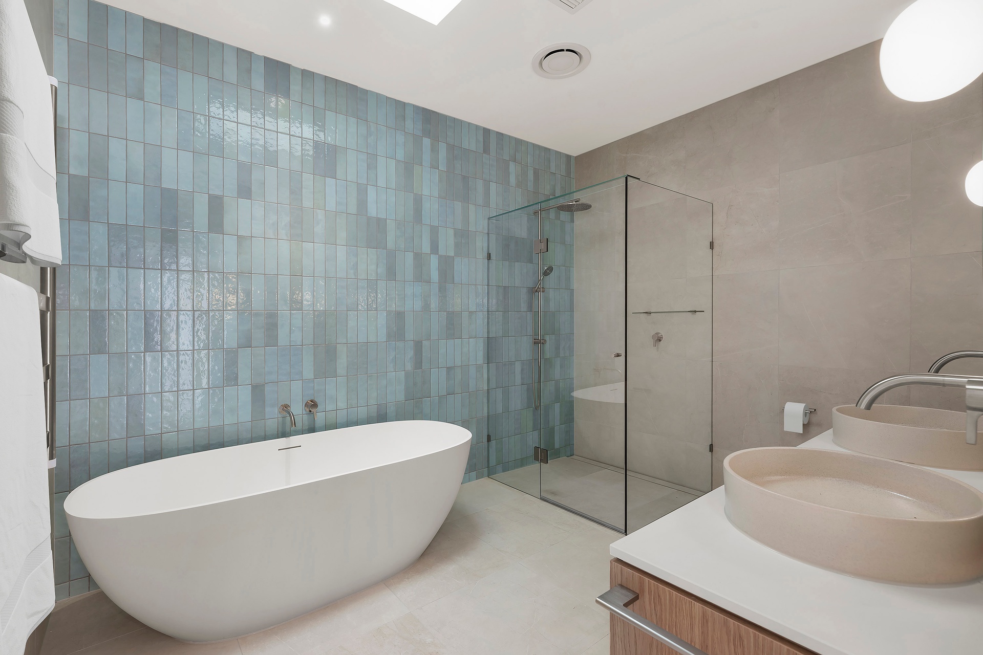 Freestanding white bathtub against blue tiles