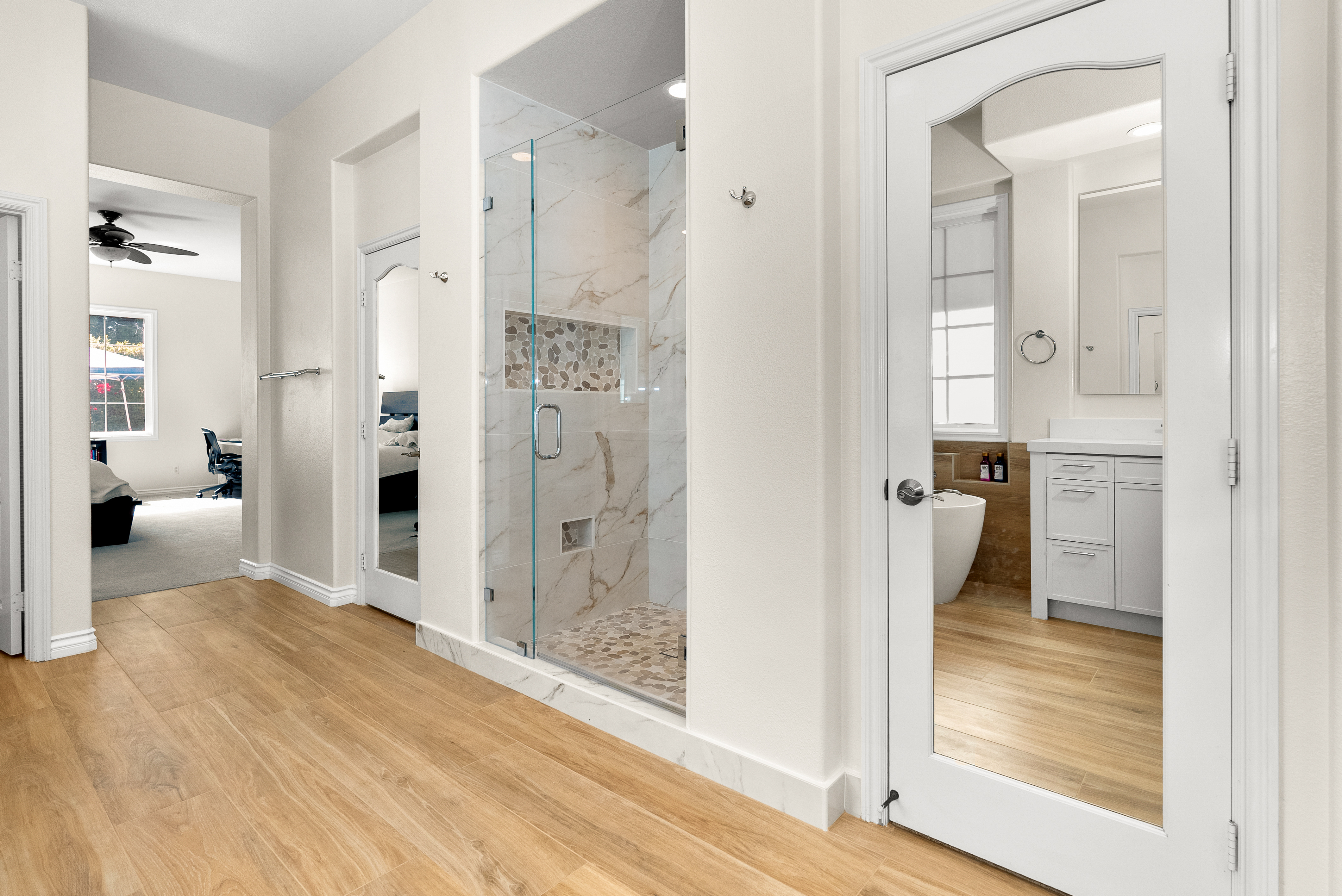 Glass-enclosed shower area featuring marble tiles