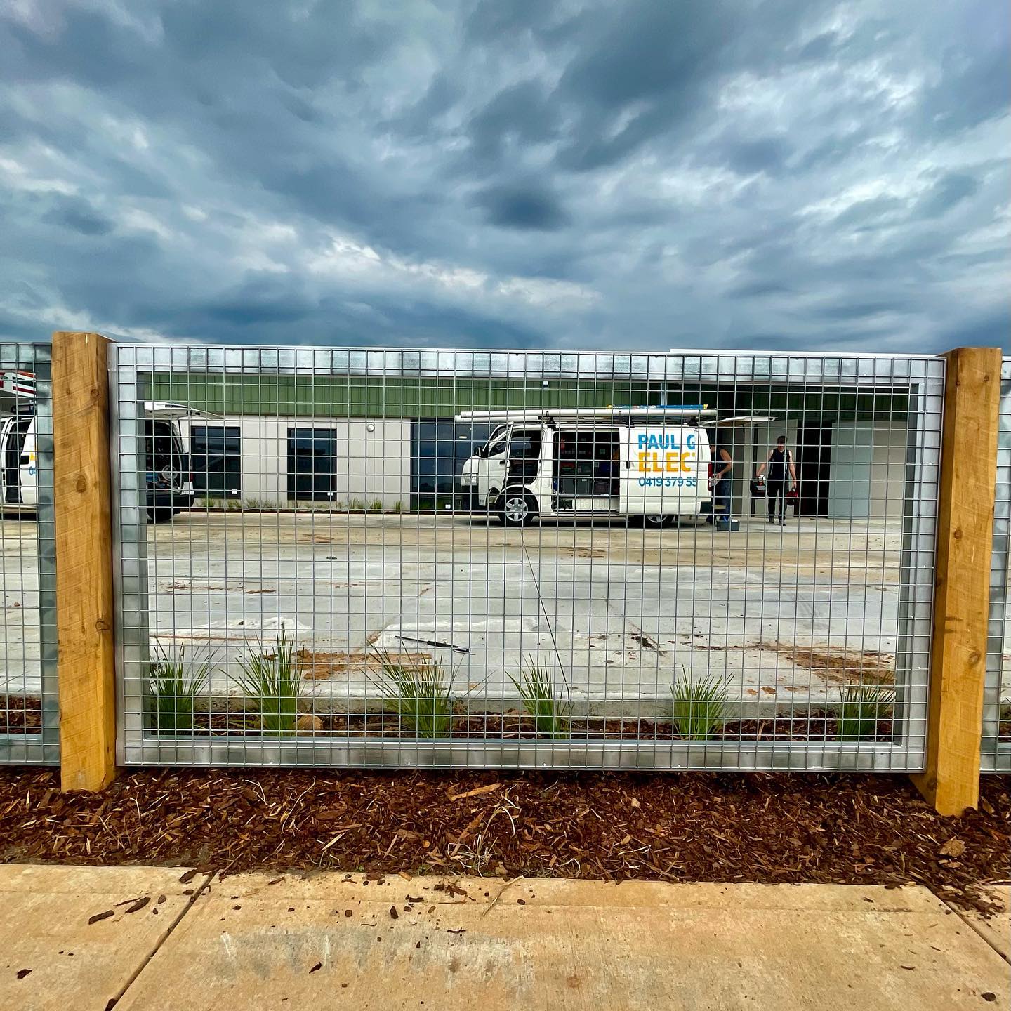 Custom Raw Galvanized Wire Sheets in Hoppers Crossing: A Unique and Flashy Installation 5 Utility vans parked near commercial building with installed fence
