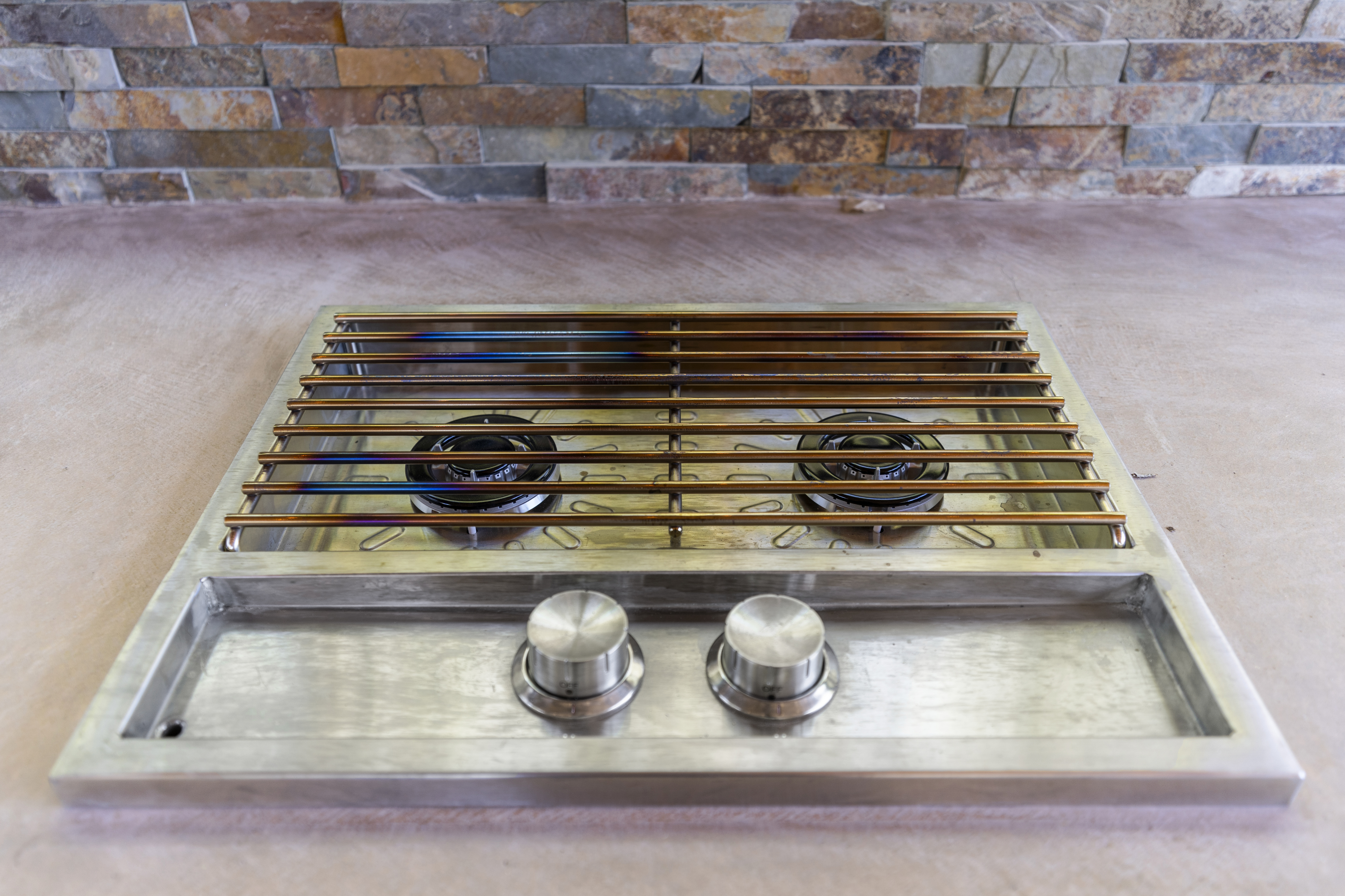 Built-in barbecue grill set into polished stone countertop