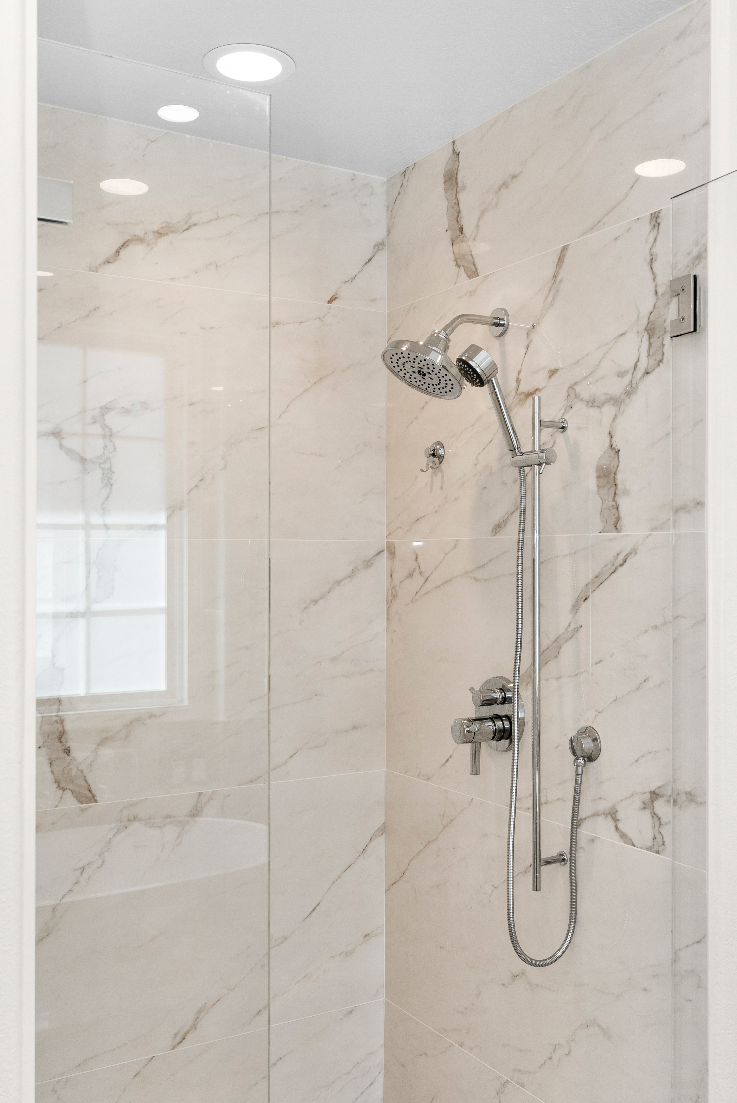 Modern shower area featuring chrome fixtures