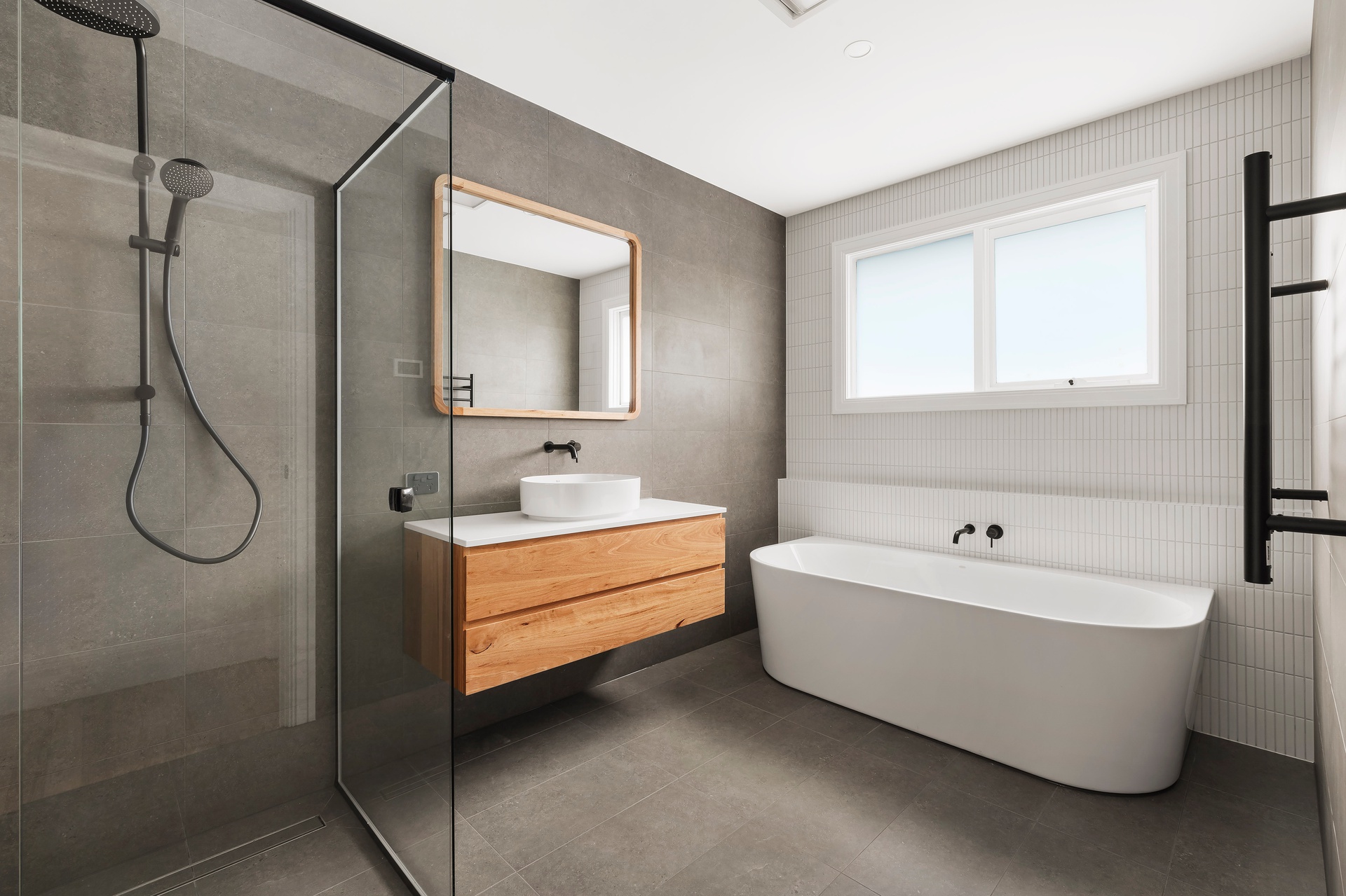 Freestanding bathtub next to large window