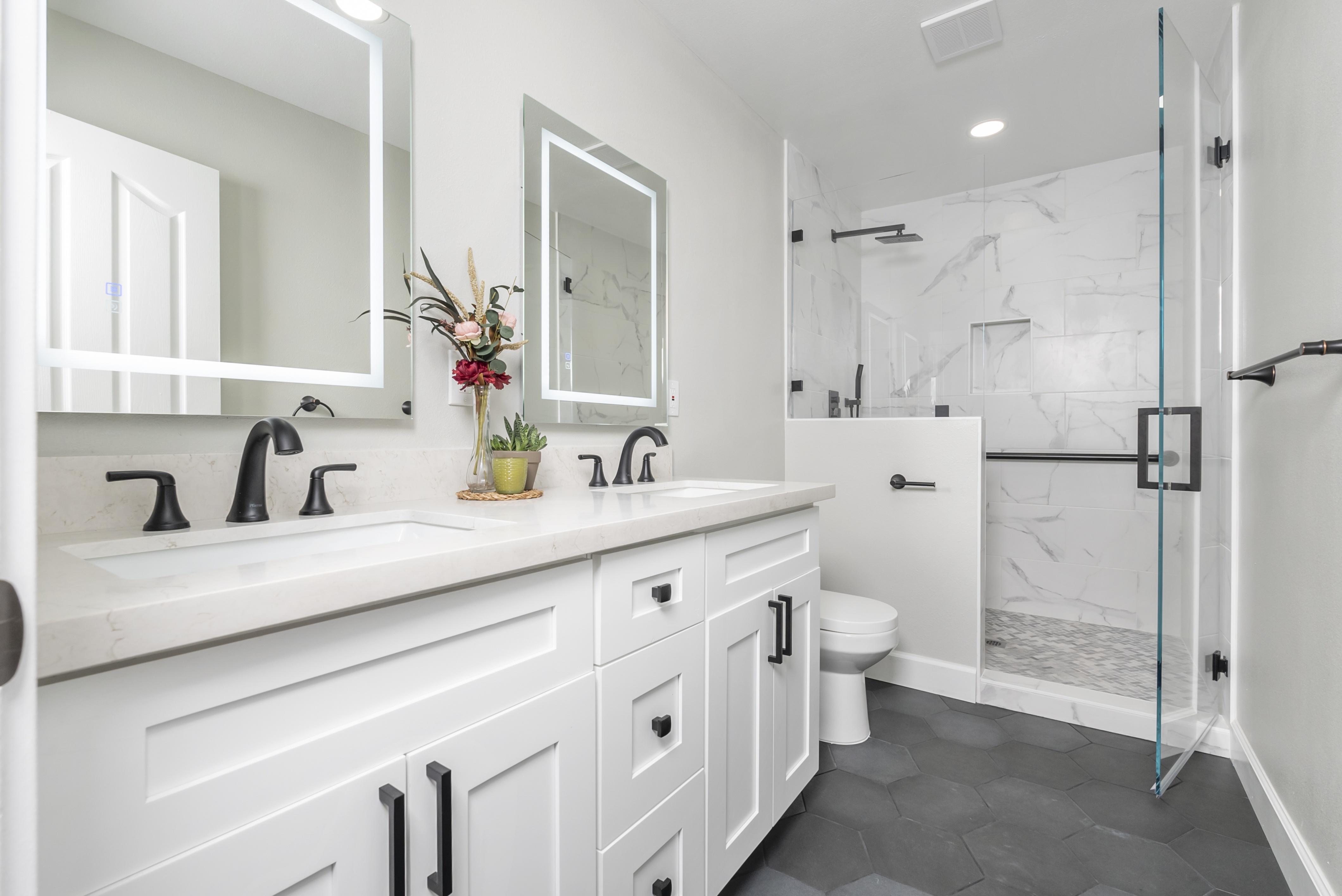 Double vanity with white cabinets and integrated lighting