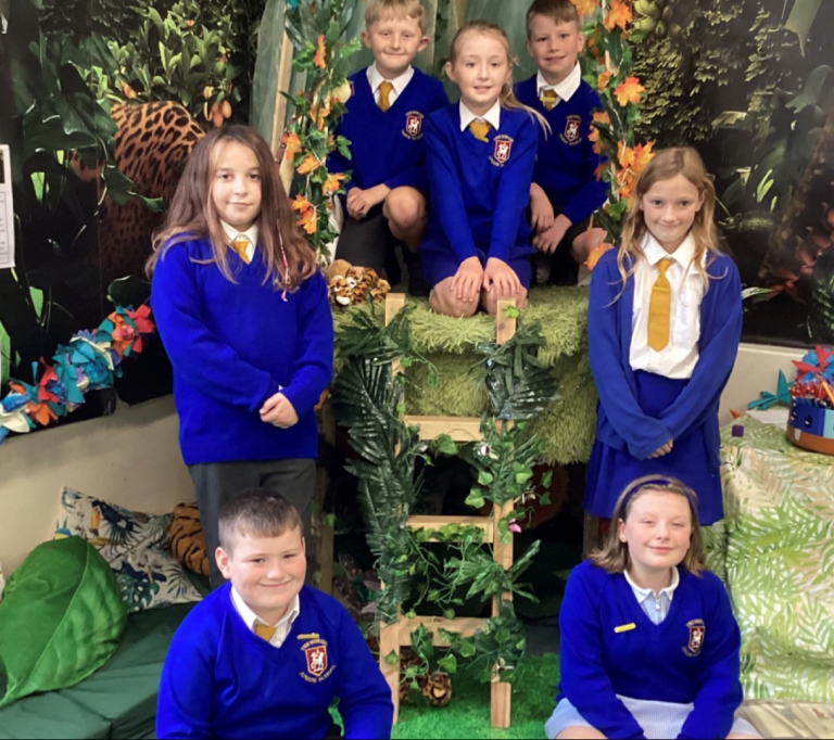 Happiness Champions at Trewirgie exude joy amidst a vibrant jungle-themed classroom setting.