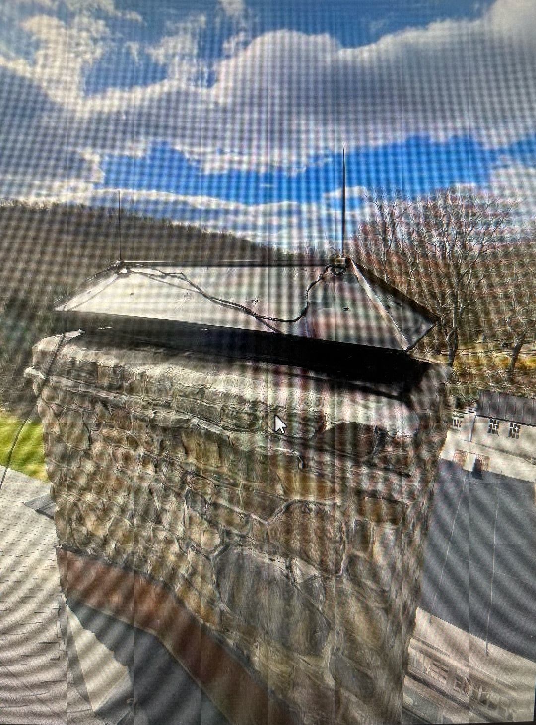 Damaged metal chimney cap with rust and holes