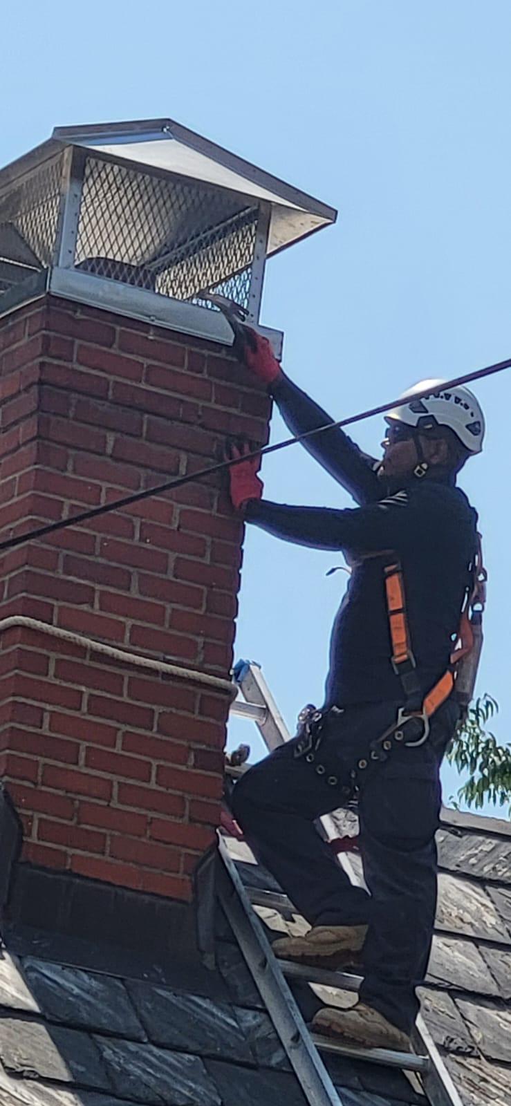 Fitting a mount cap over the crown of a red-brick chimney