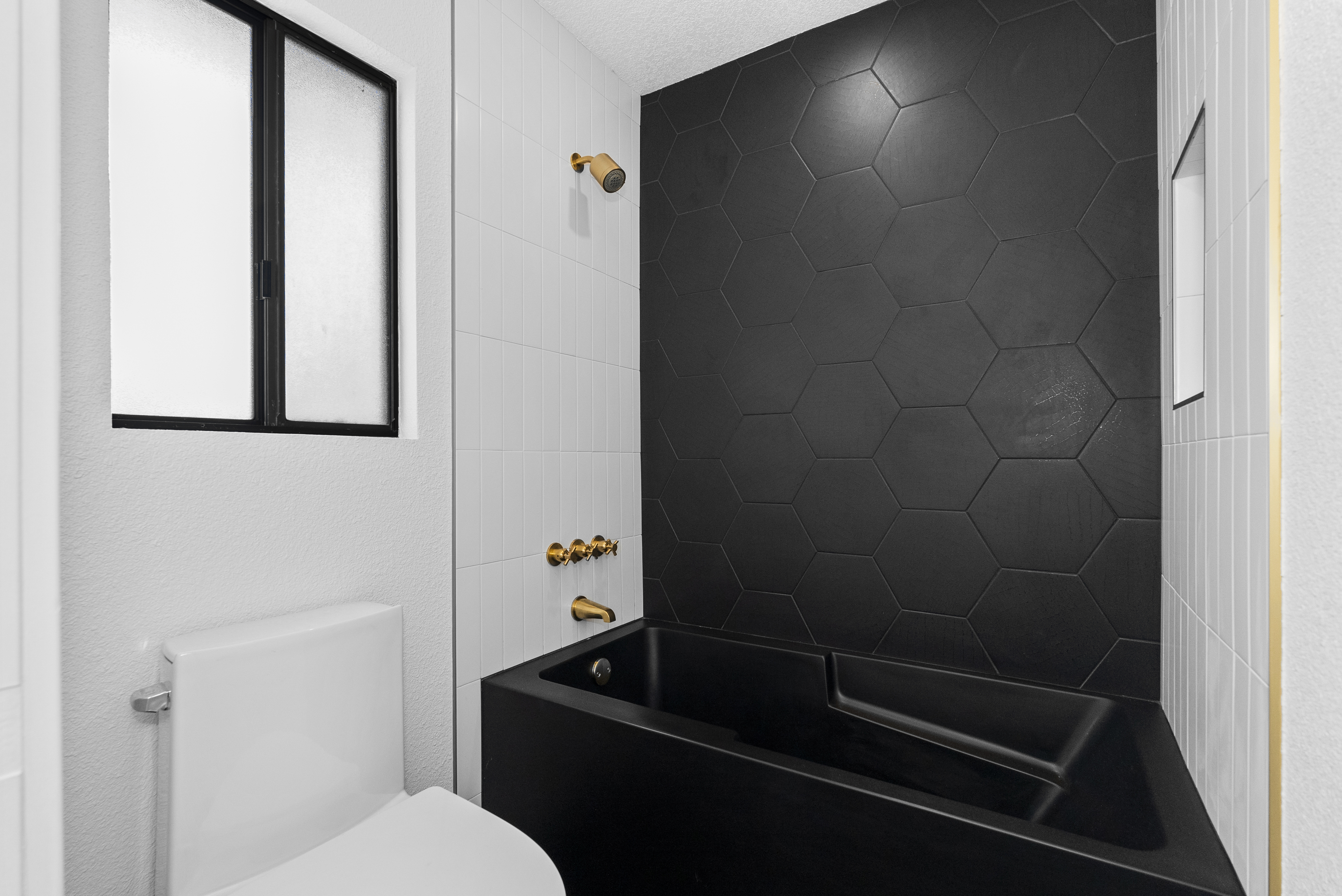 Contemporary black bathtub against tiled wall