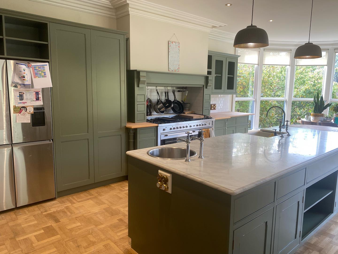 Resurfaced green cabinetry with marble countertop