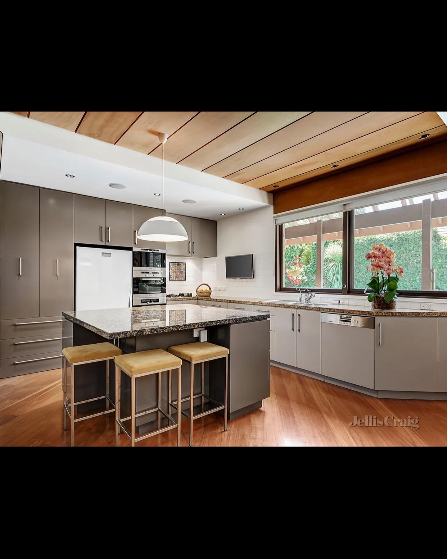 Modern kitchen with central island featuring granite countertop