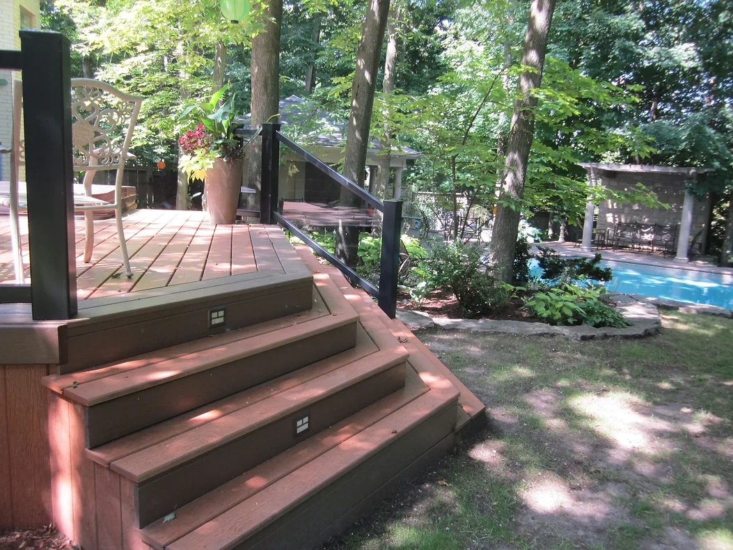 A serene deck overlooking a lush garden with pool - Form A Fence's craftsmanship