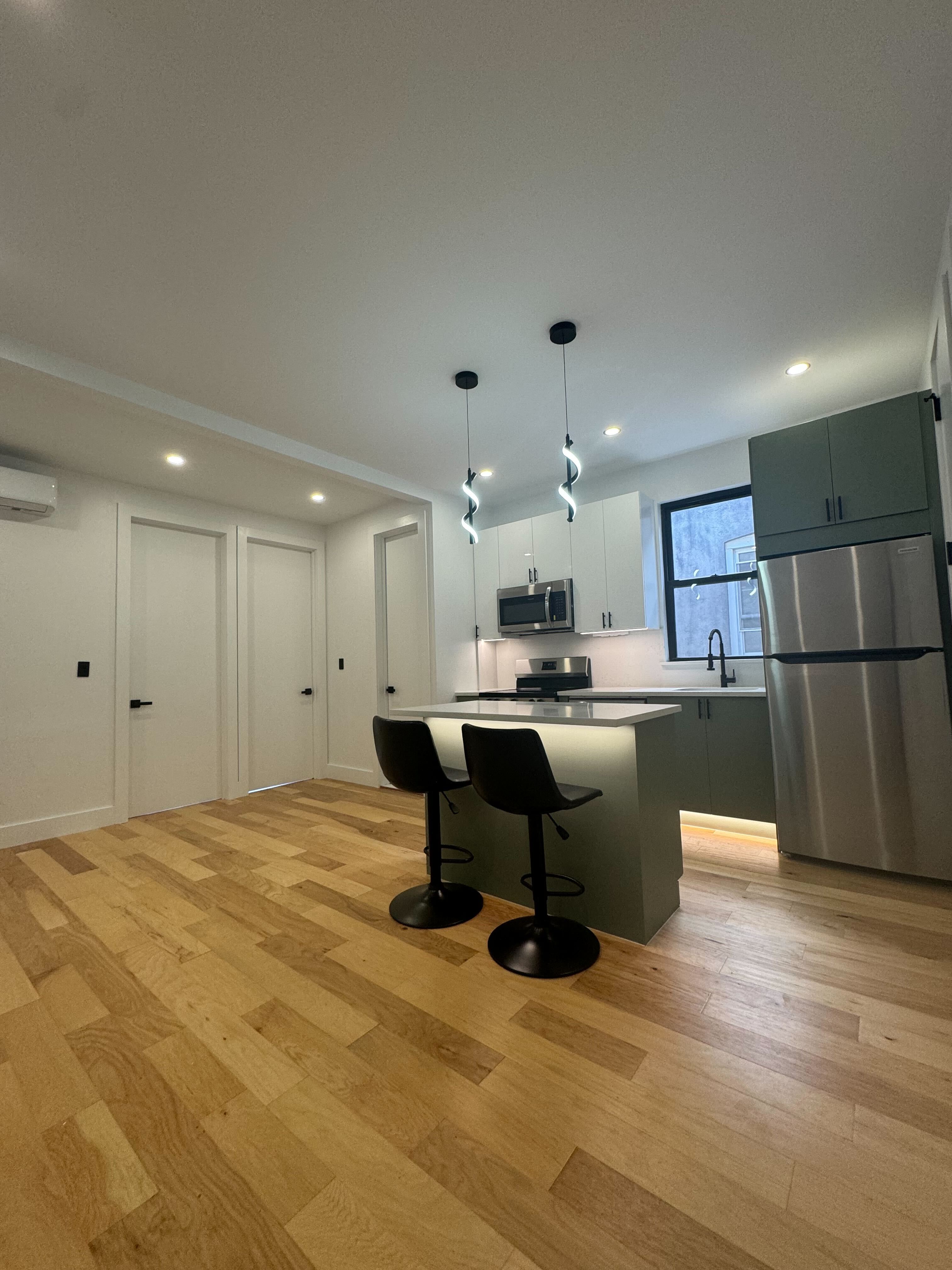 Modern kitchen area with light wood flooring