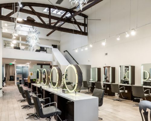 Interior view of a modern beauty salon featuring styling stations
