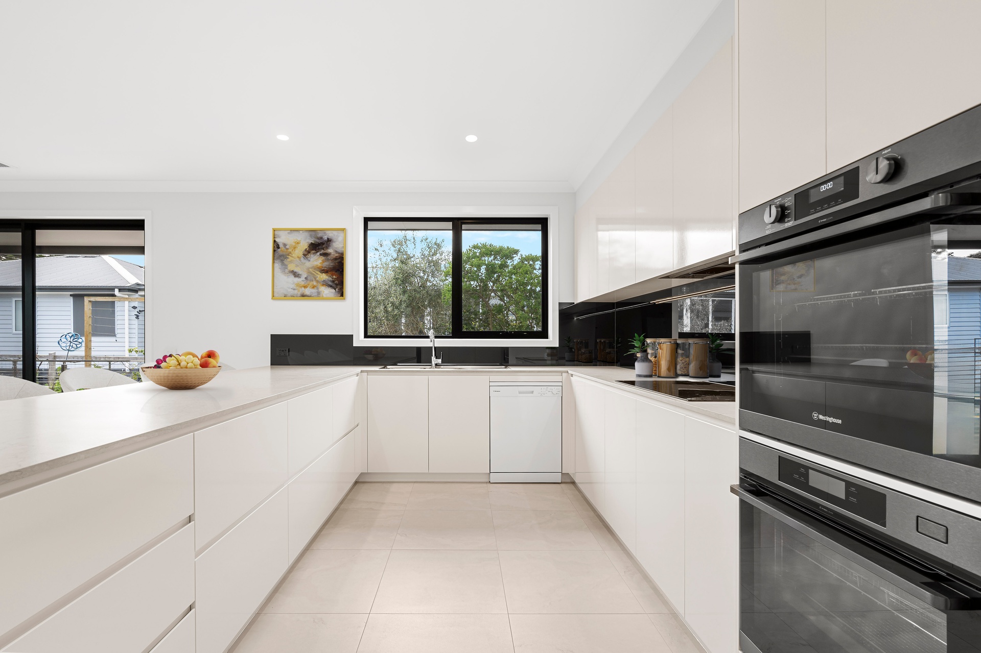 Modern kitchen featuring U-shaped layout with sleek white cabinetry