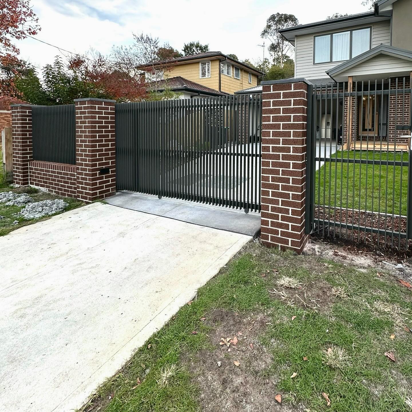 Beautiful Woodland Grey Blade Style Package in Diamond Creek 7 Modern gate system at residential entrance