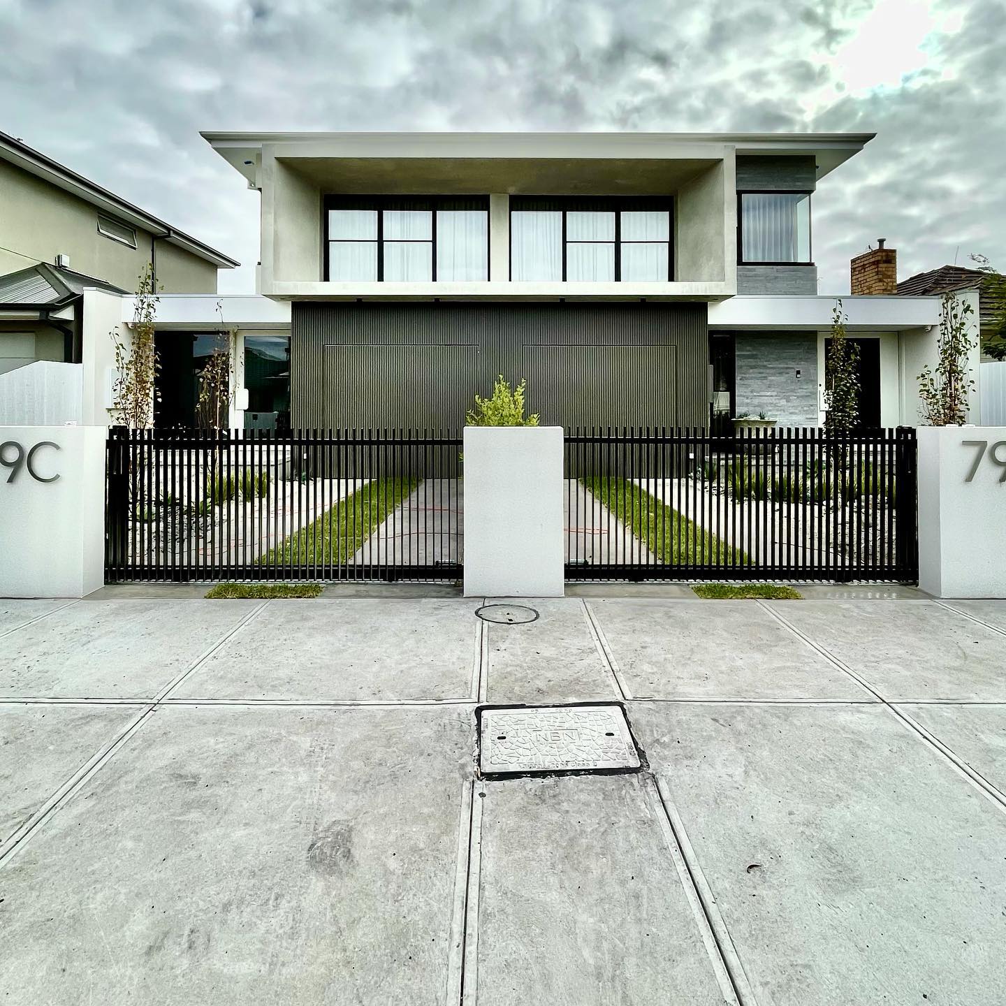Elegant Satin Black Fencing with Twin Auto Sliders for Altona North Townhouses 2 Twin modern townhouses with symmetrical design