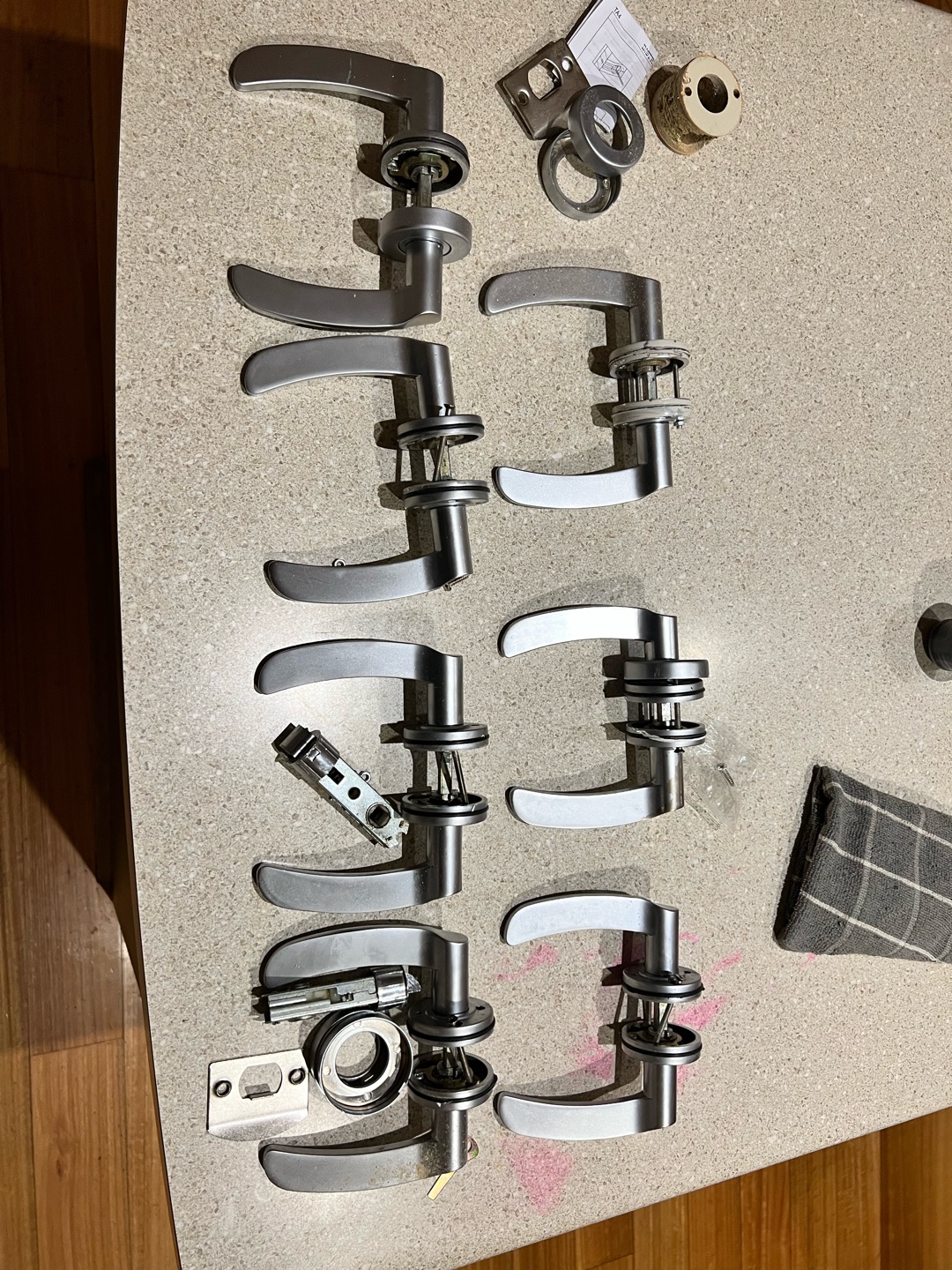 Multiple silver door levers arranged on a countertop