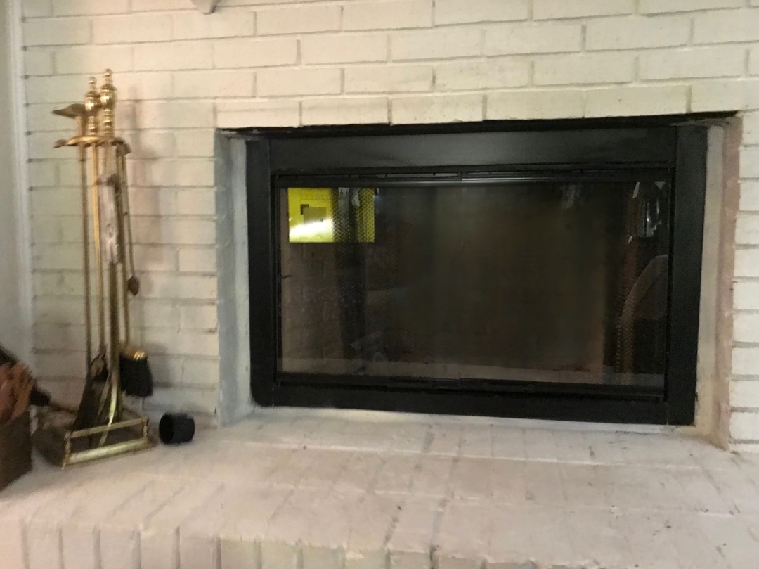 Newly installed prefabricated fireplace with modern black frame