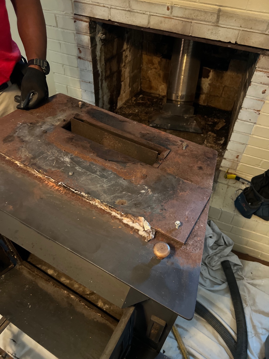 Technician removing old stove from fireplace