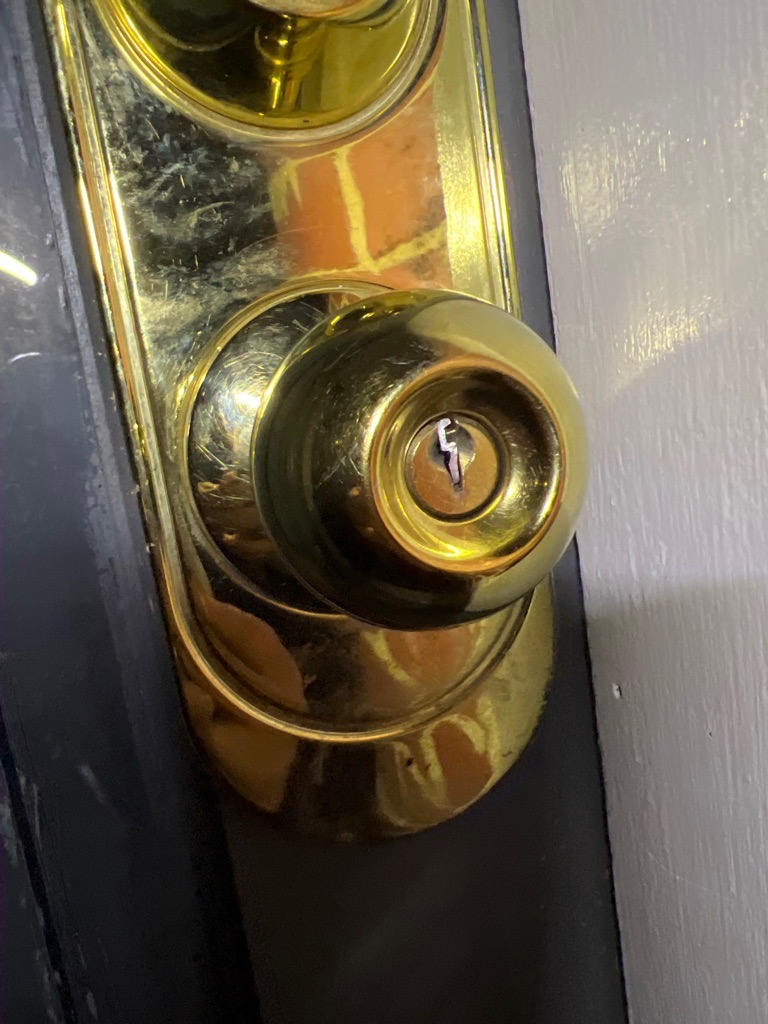 Close-up of brass door knob with broken key fragment lodged inside