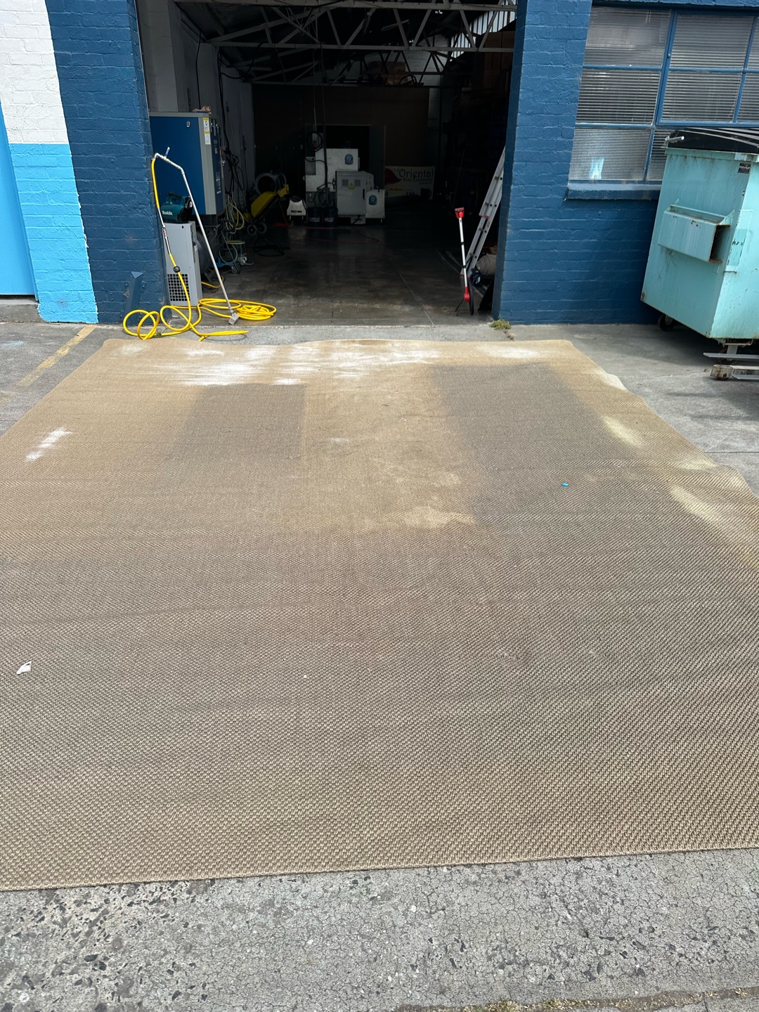 Cleaning equipment visible as jute rug is being cleaned