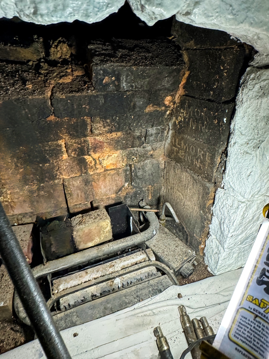Interior of firebox with broken bricks and old gas unit