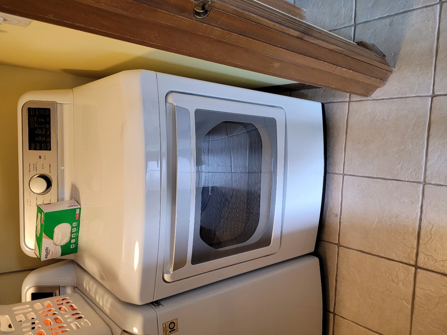 White front-loading dryer with laundry basket inside