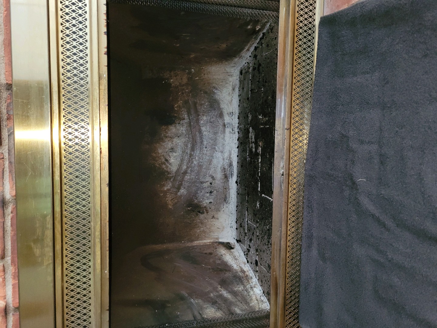 Fireplace with brass frame showing soot accumulation