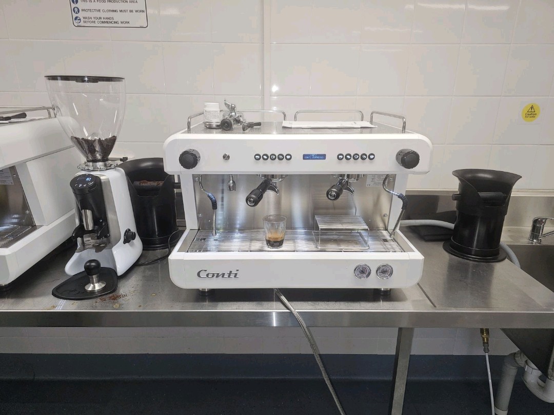 A close-up view of one Conti espresso machine with a grinder.