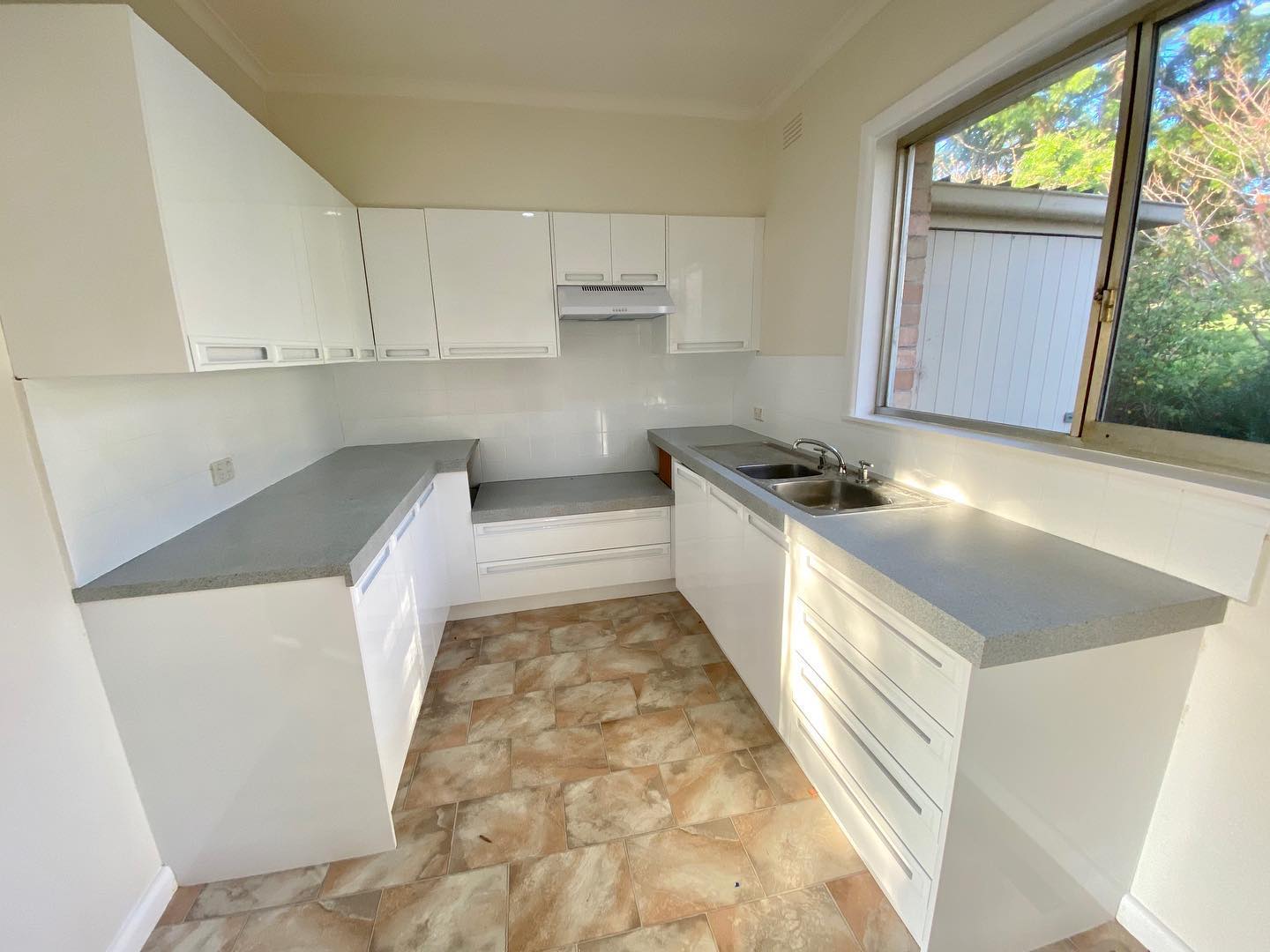 White kitchen cabinets with glossy finish after resurfacing