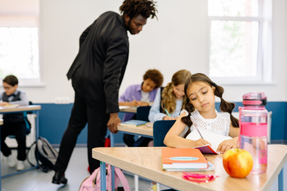 A male observer attentively overseeing a student's work