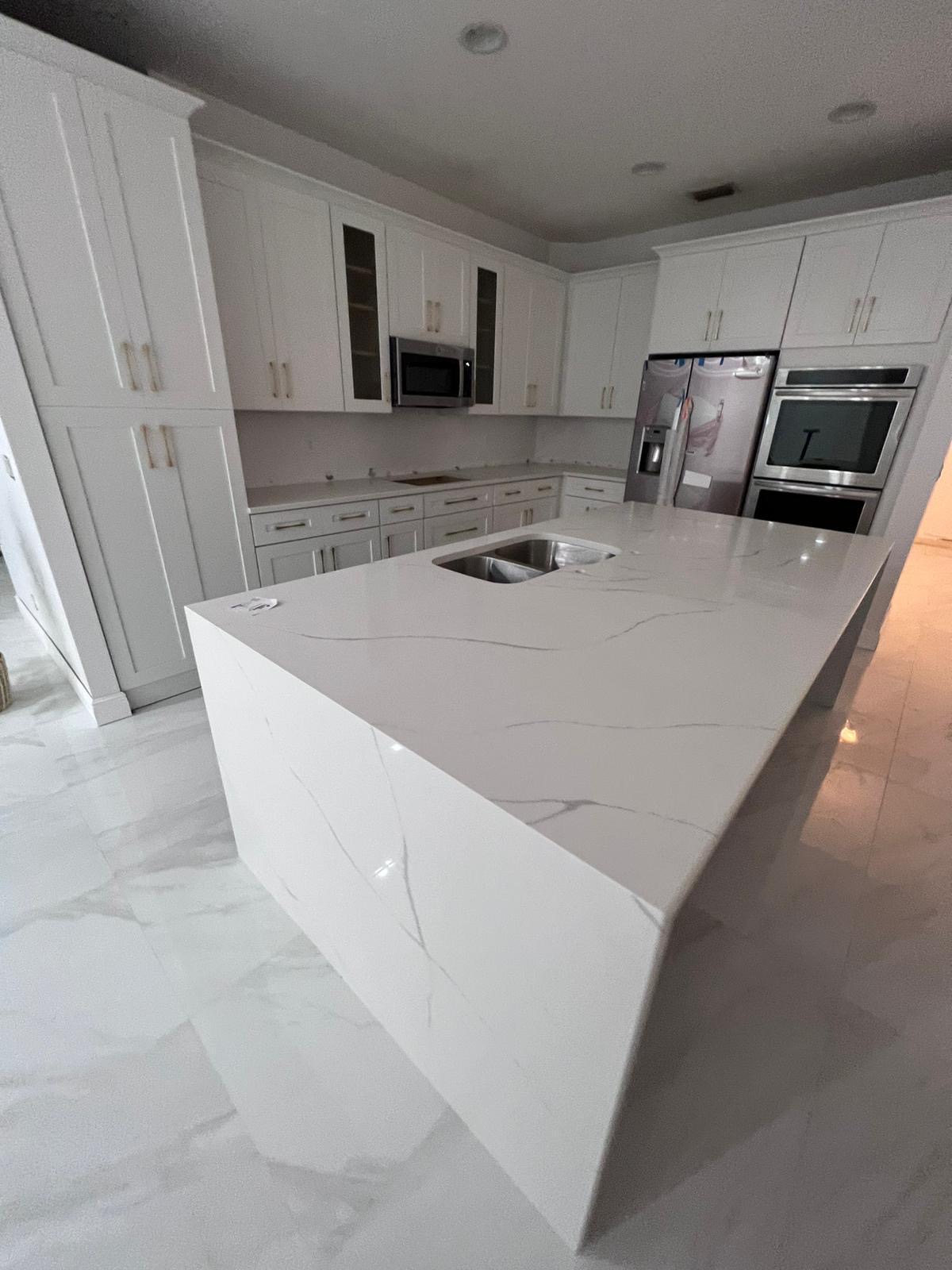 Modern kitchen remodel featuring white marble countertops and sleek cabinetry