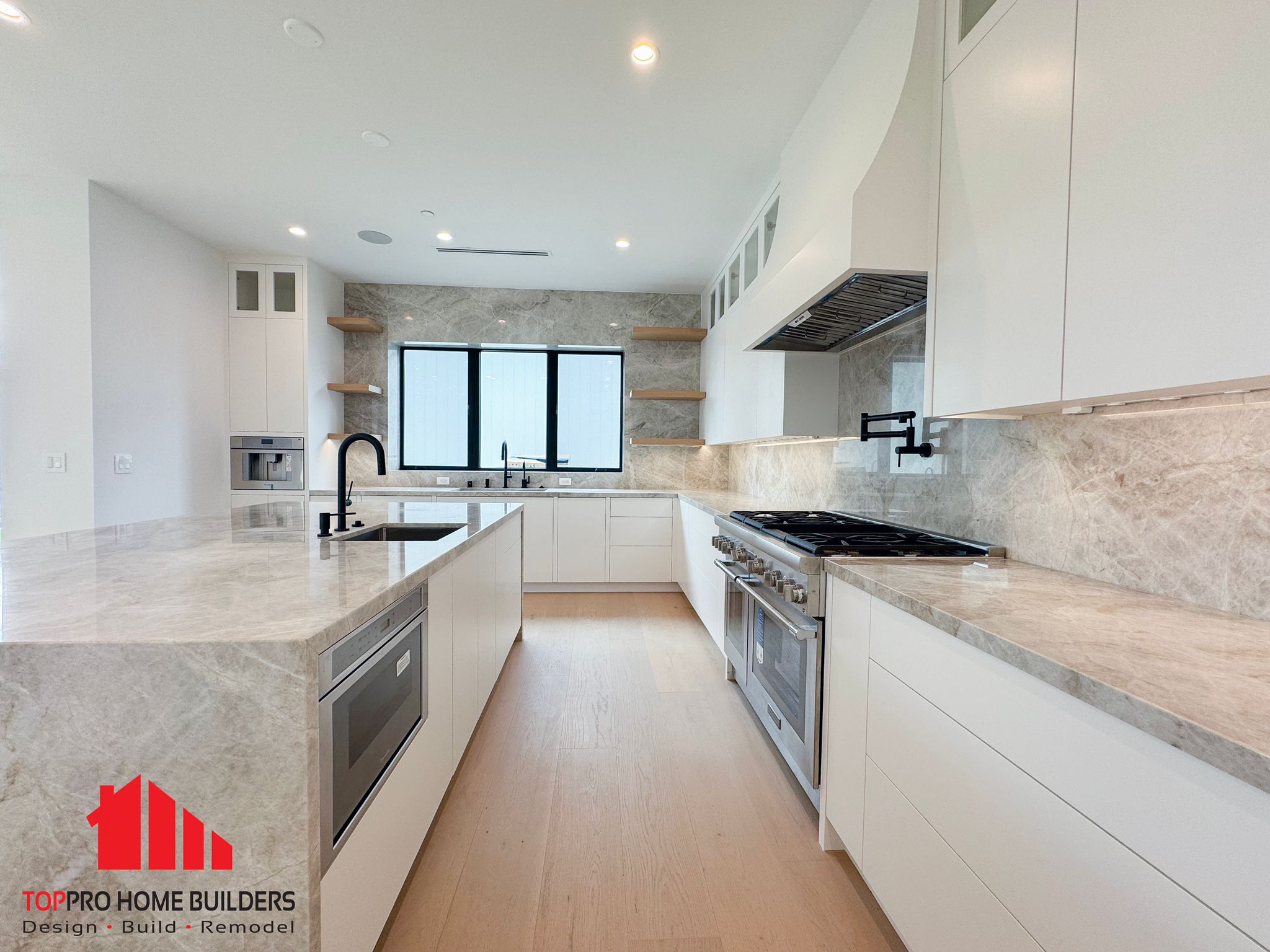 Modern kitchen showcasing white cabinetry and marble countertops