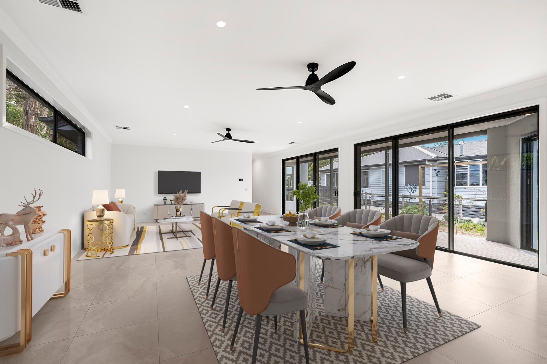 Open-plan living area featuring marble dining table surrounded by upholstered chairs