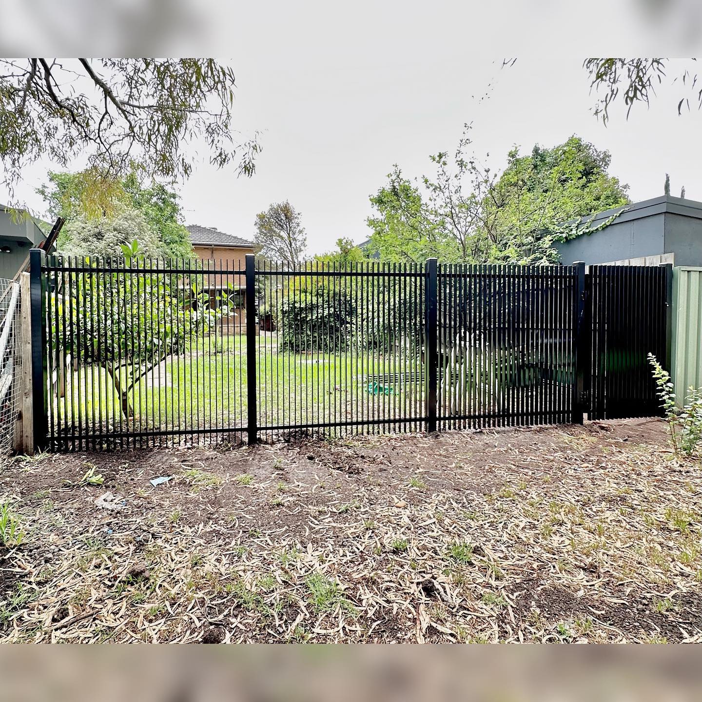 Black metal fence with vertical bars spanning the width of the frame