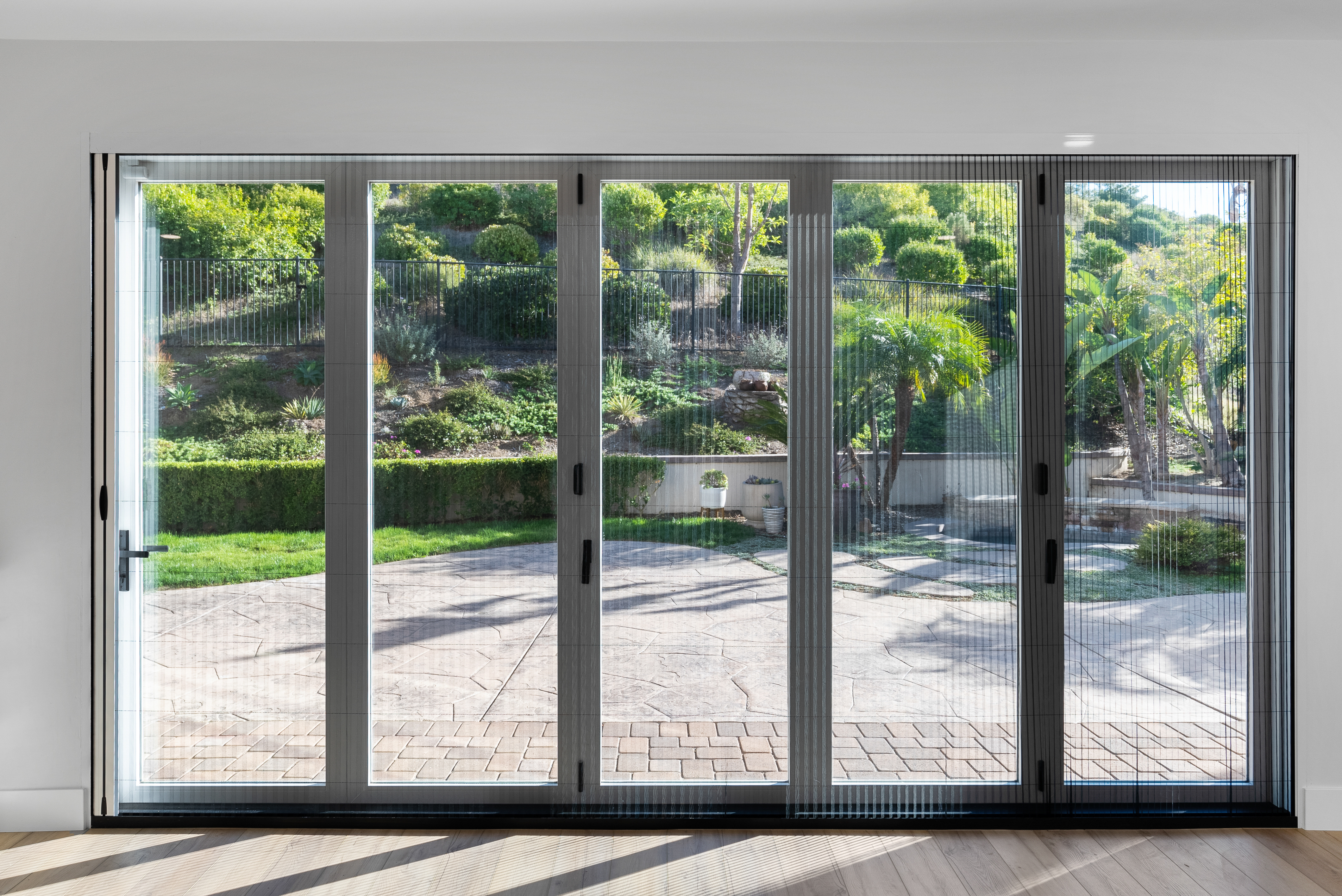 Large sliding glass doors leading to landscaped garden