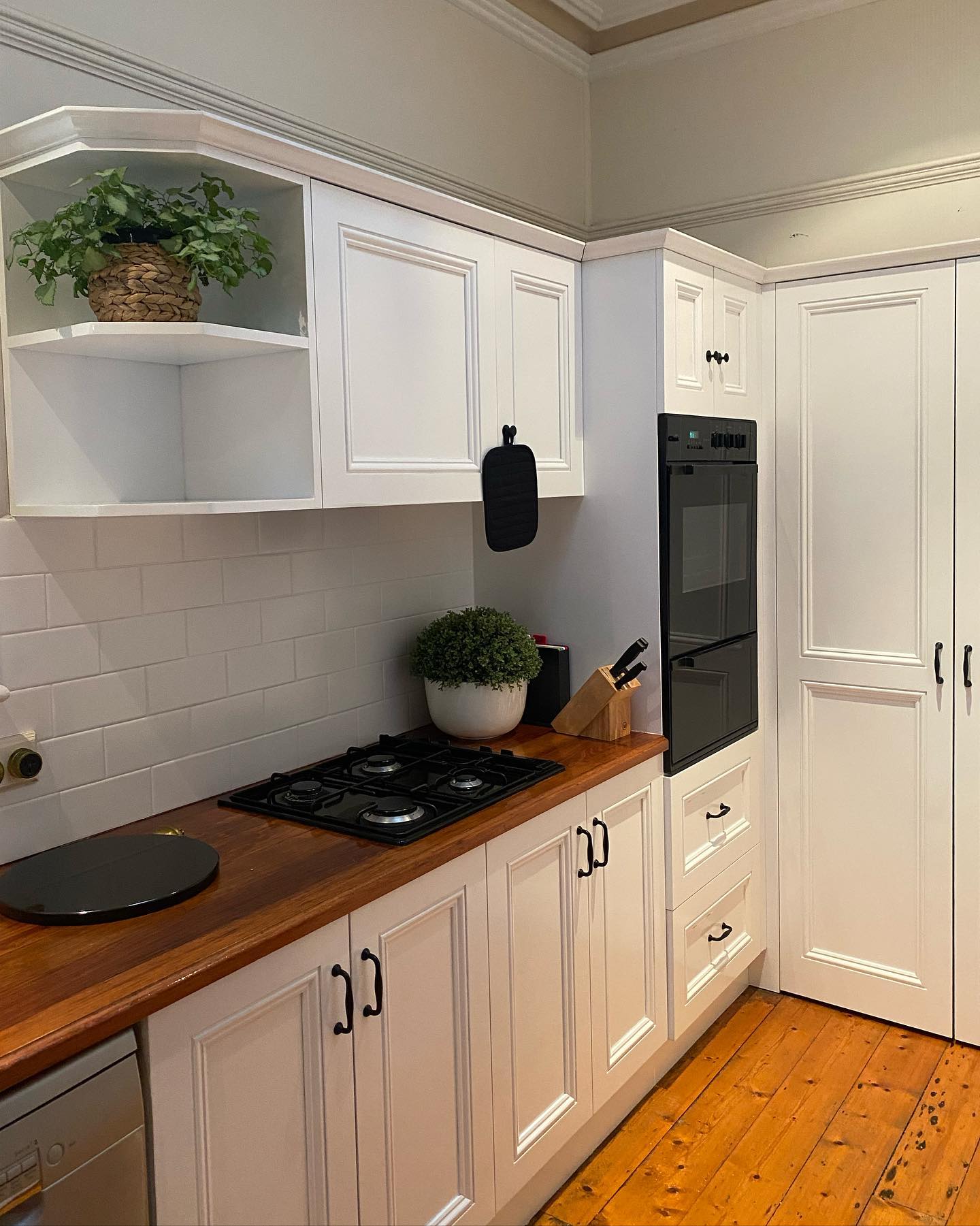 Modernized kitchen with white cabinets and wooden countertop