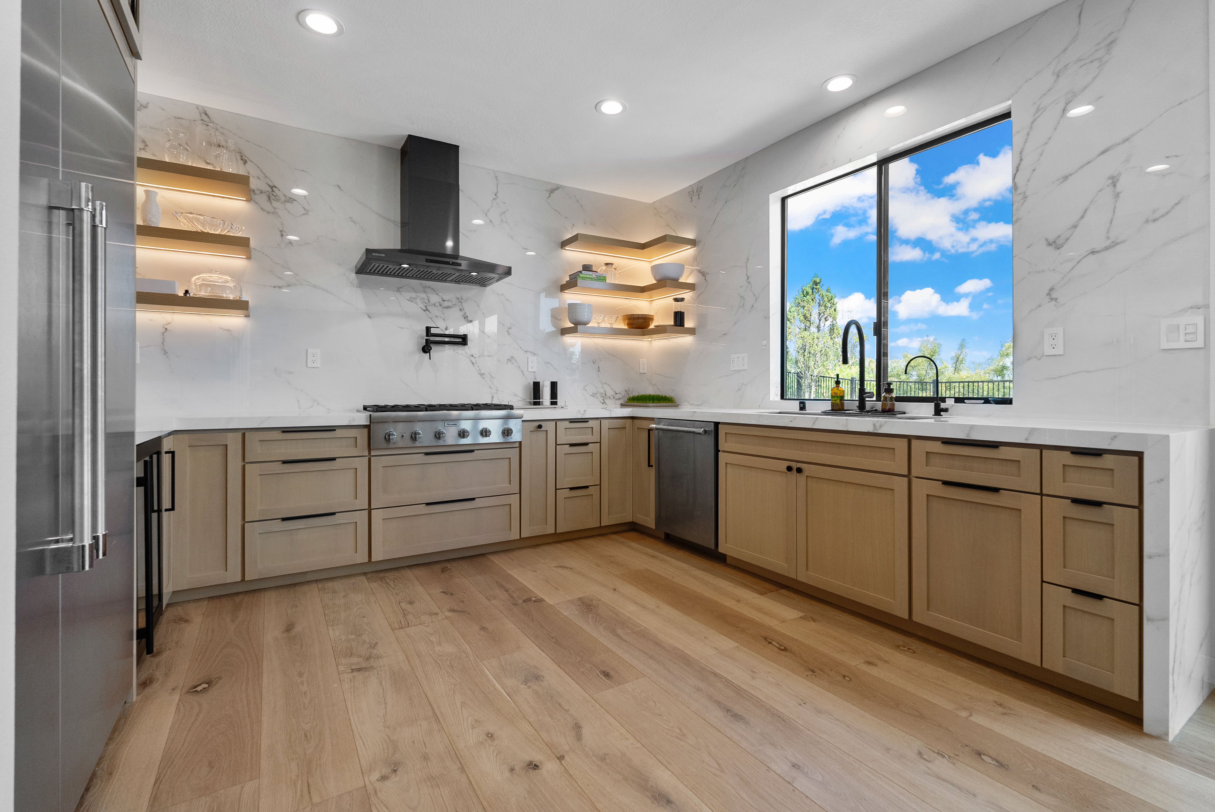 Light wood cabinetry with stainless steel appliances