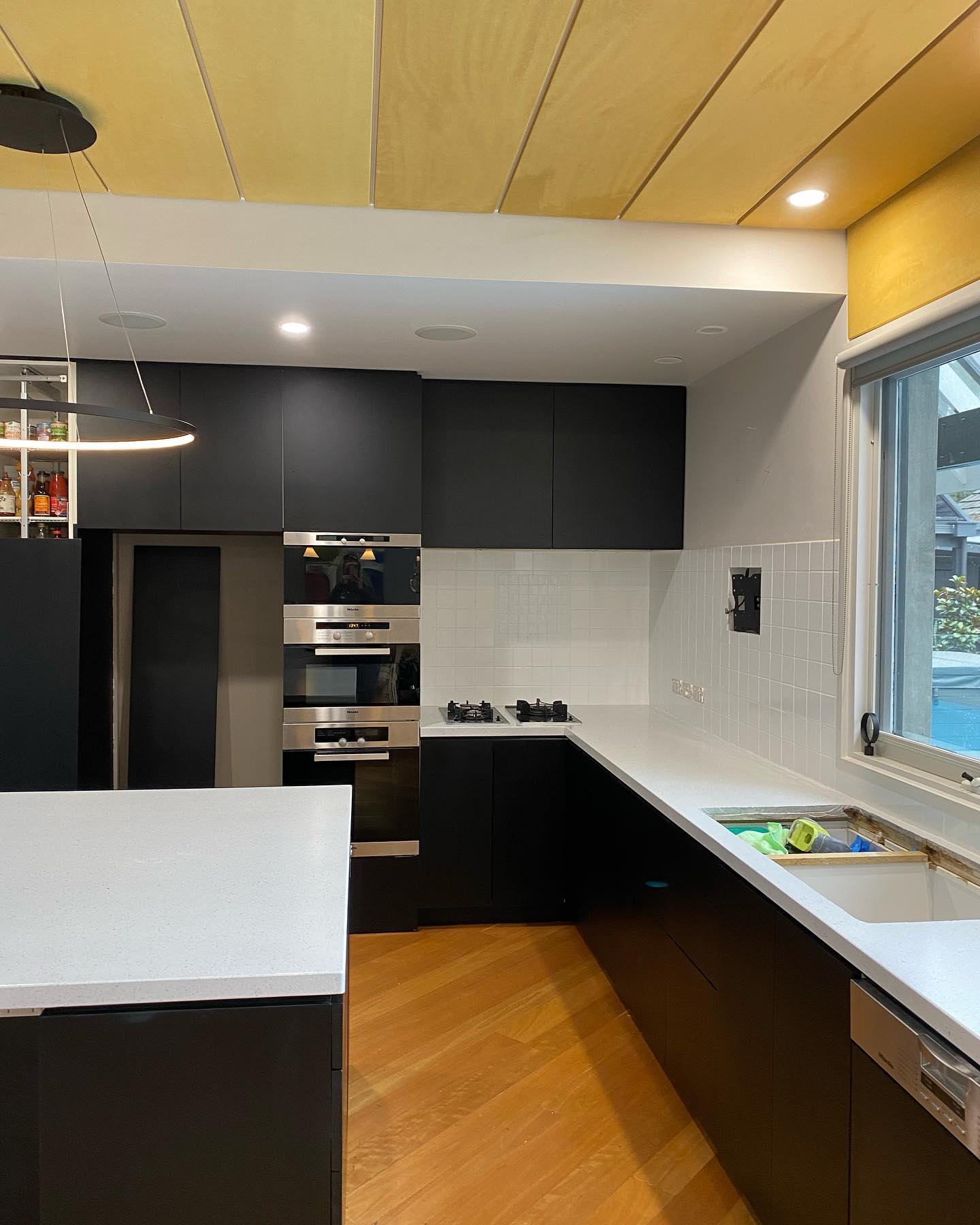 Modern kitchen with black cabinetry and white countertops