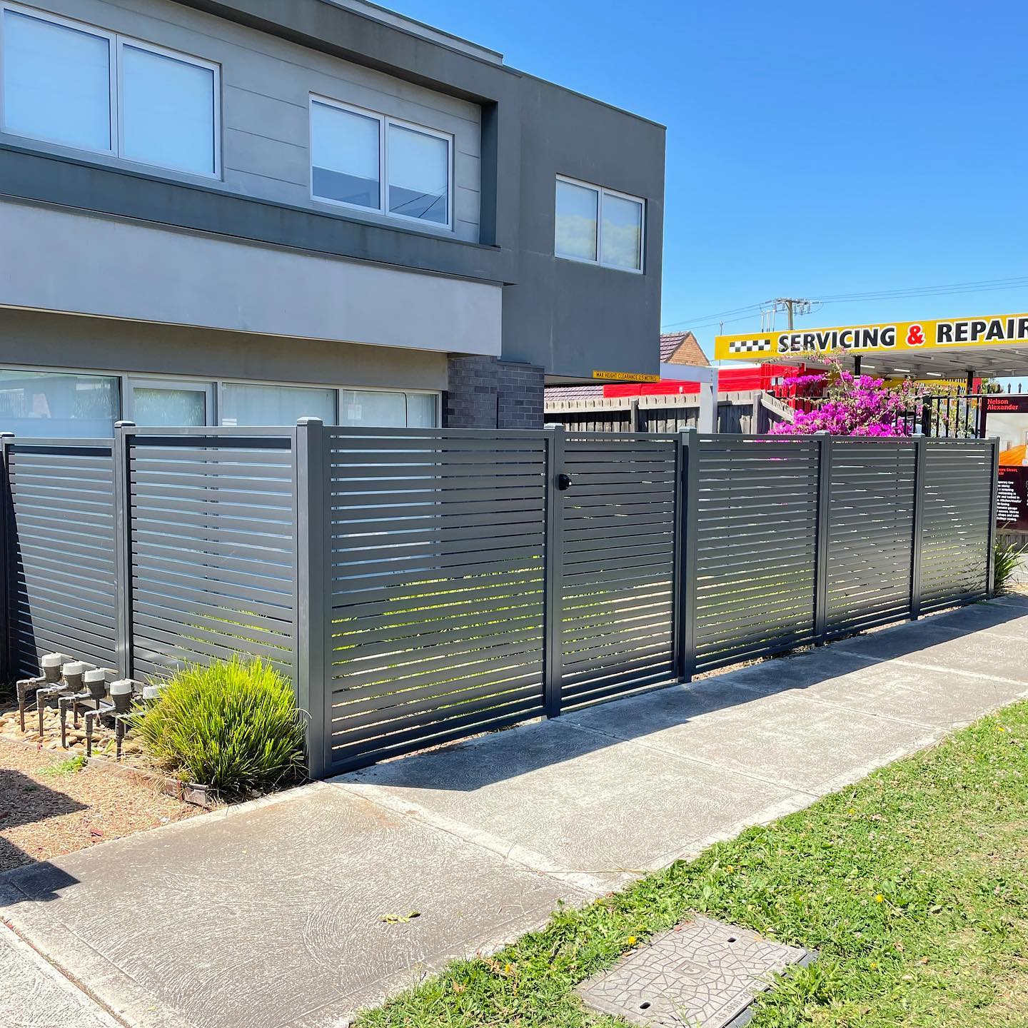 Modern dark gray horizontal metal slats fence
