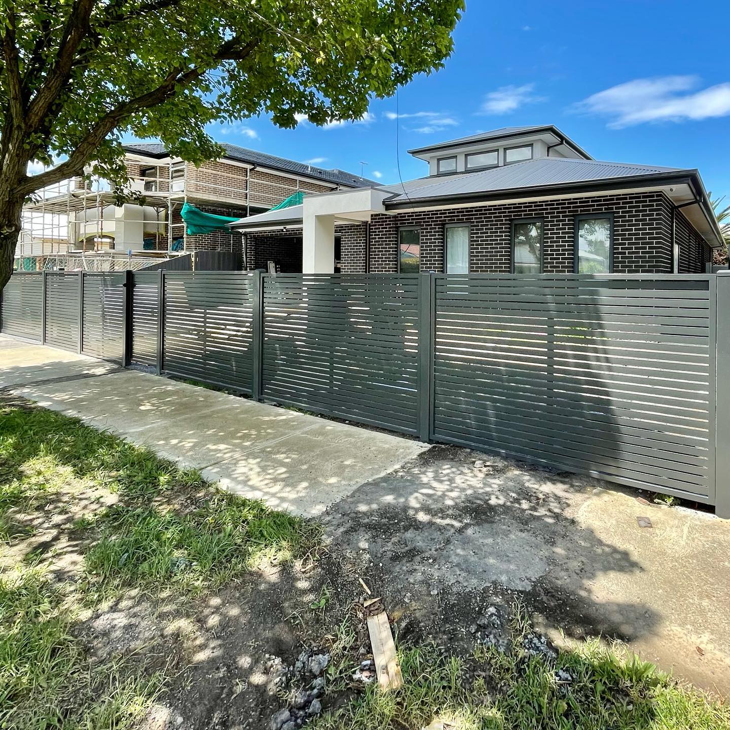 Modern Screen Fence Installation in Preston Featuring the D5 Smart Gate Motor 2 Modern screen fence with horizontal slats extending along the front of a residential property