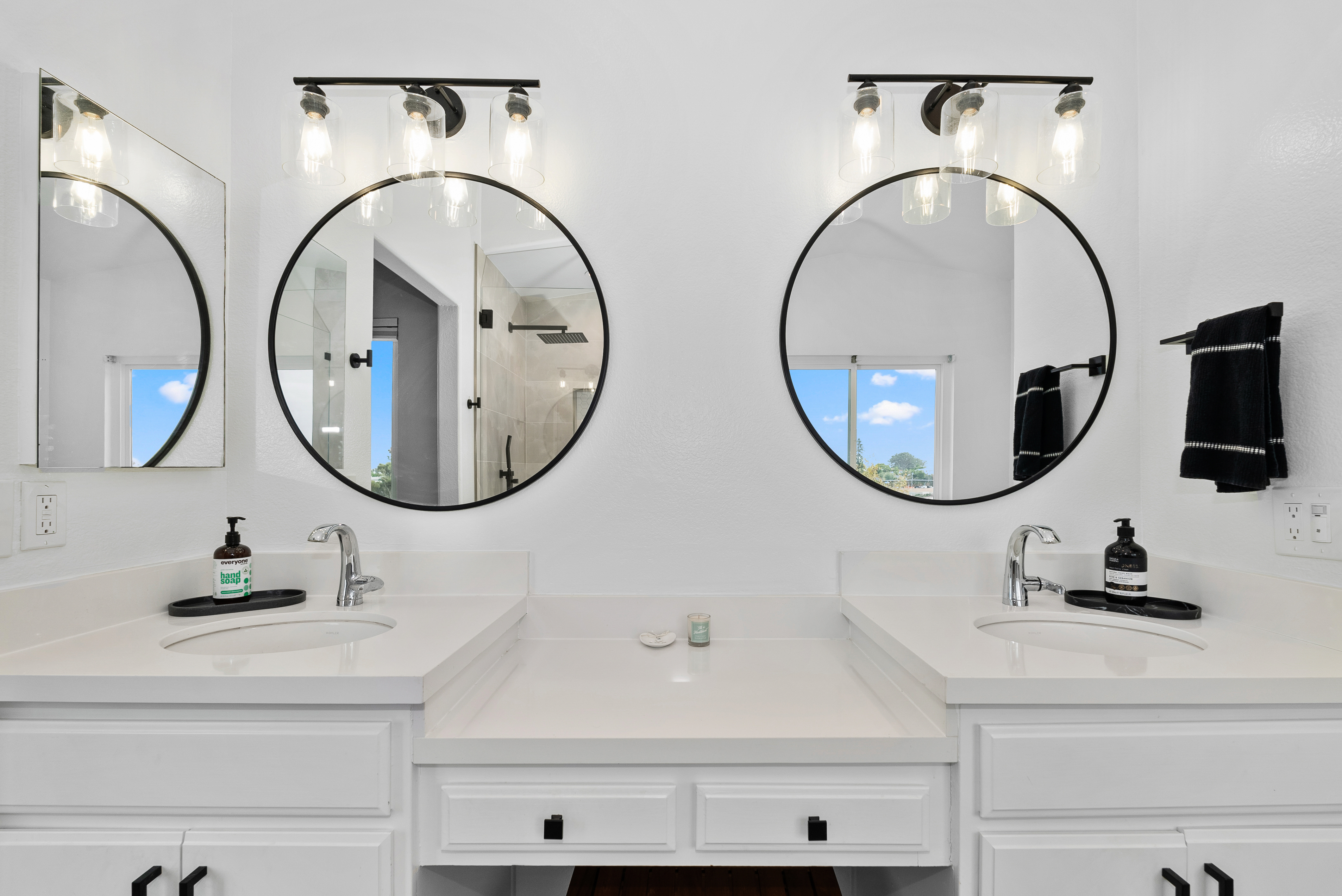 Double vanity setup with circular mirrors and white porcelain sinks