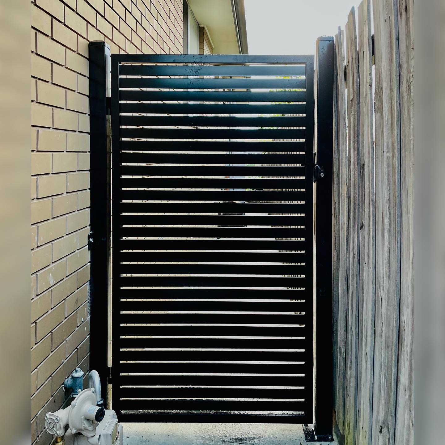 Black pedestrian gate with horizontal slats