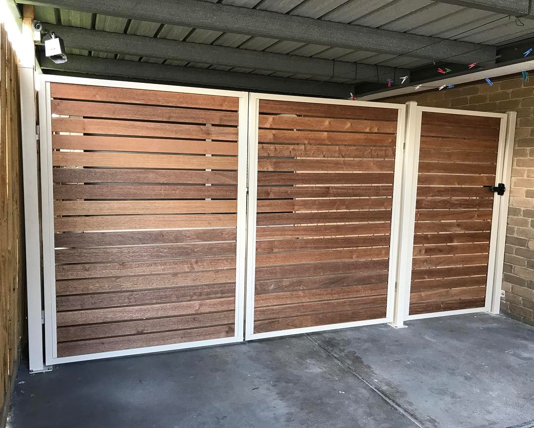 Double swing gates and pedestrian gate with powder-coated steel frames clad with Merbau slats